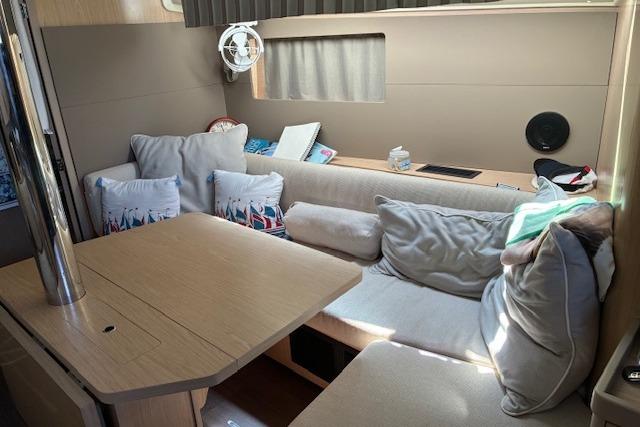 Cozy interior of 2017 Beneteau Oceanis 41.1 sailboat with cushioned seating and table.