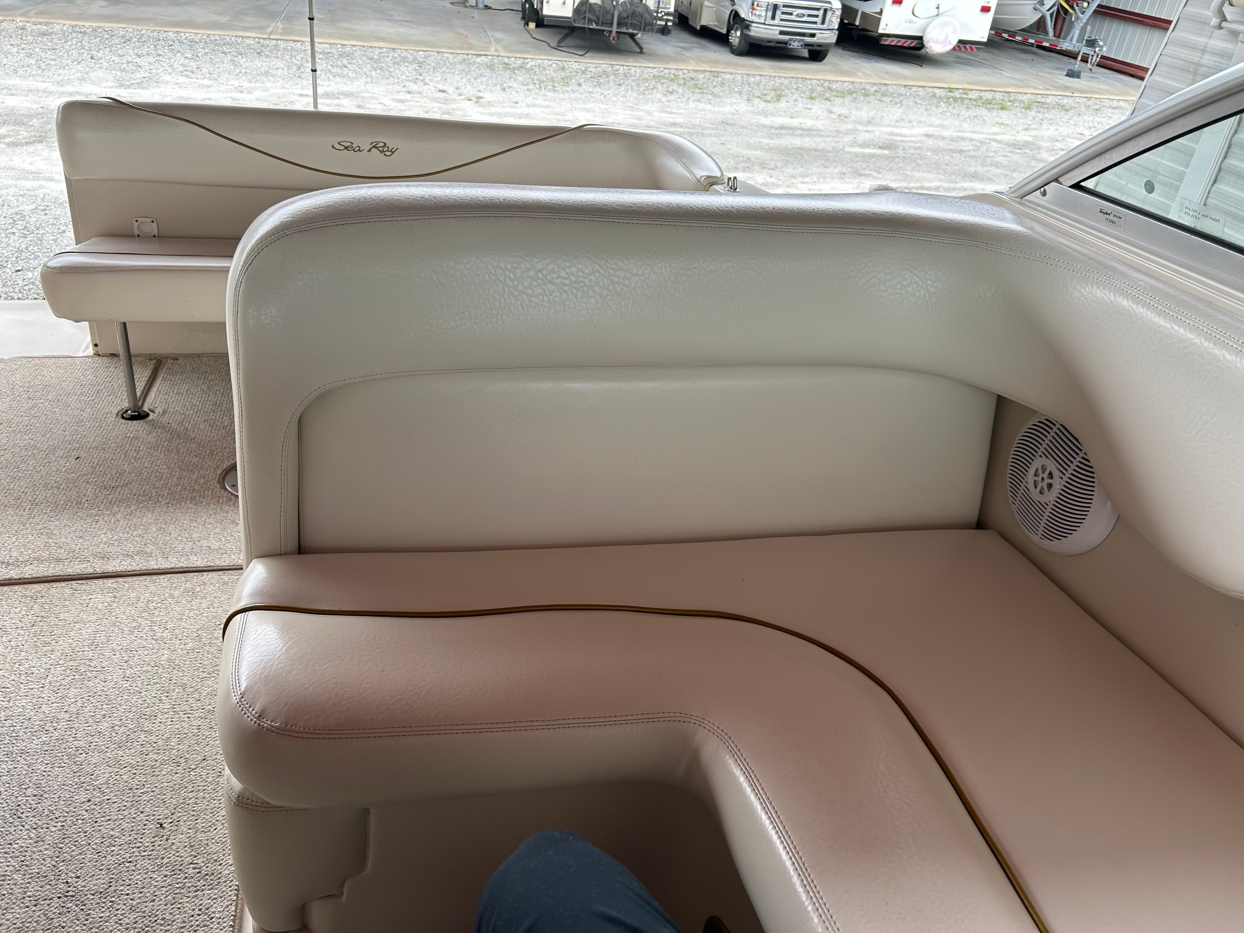 2003 Sea Ray 240 Sundancer interior with beige seating and speaker detail.