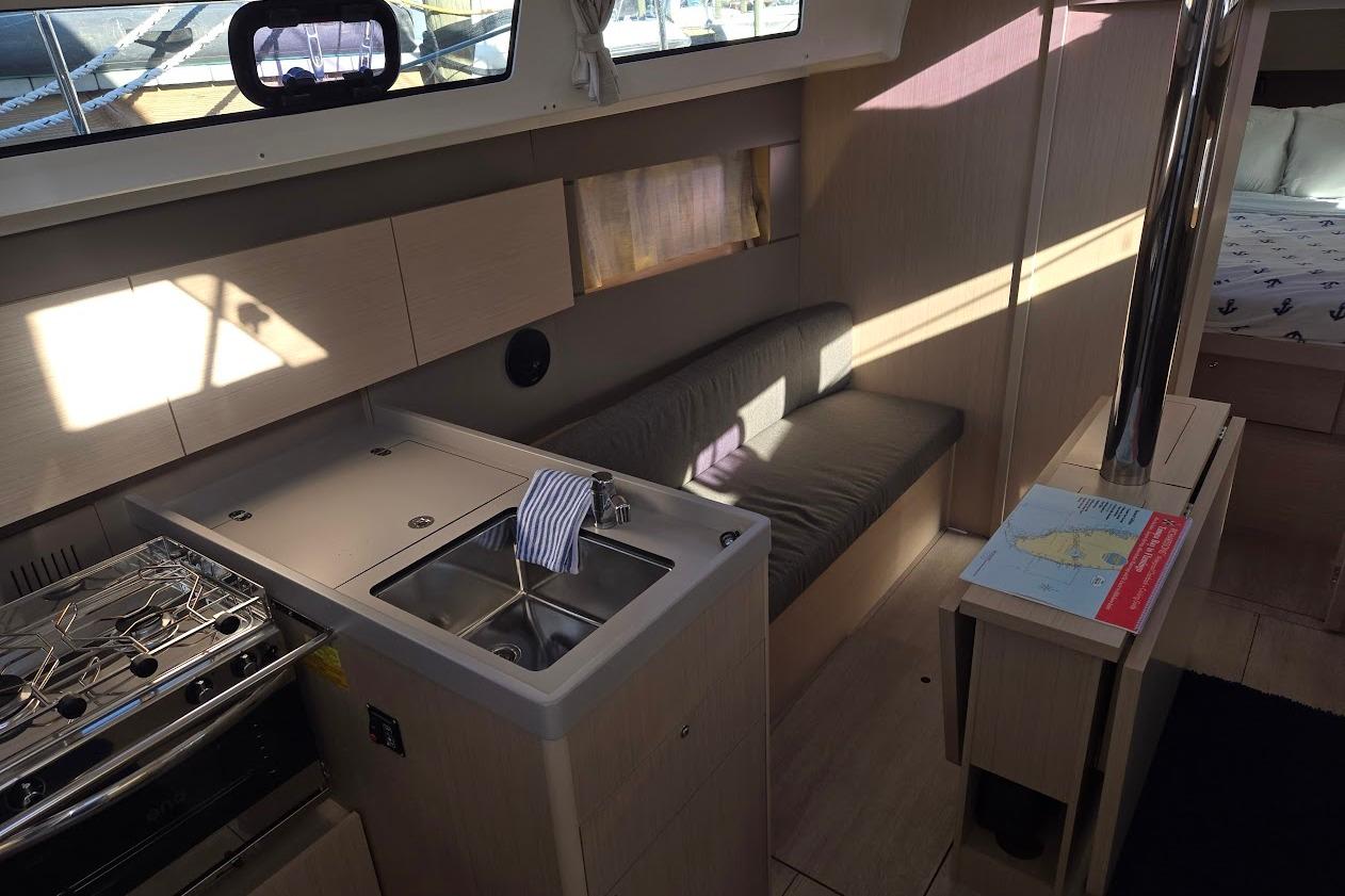 Interior of 2023 Beneteau Oceanis 38.1 yacht with modern kitchen and seating area.