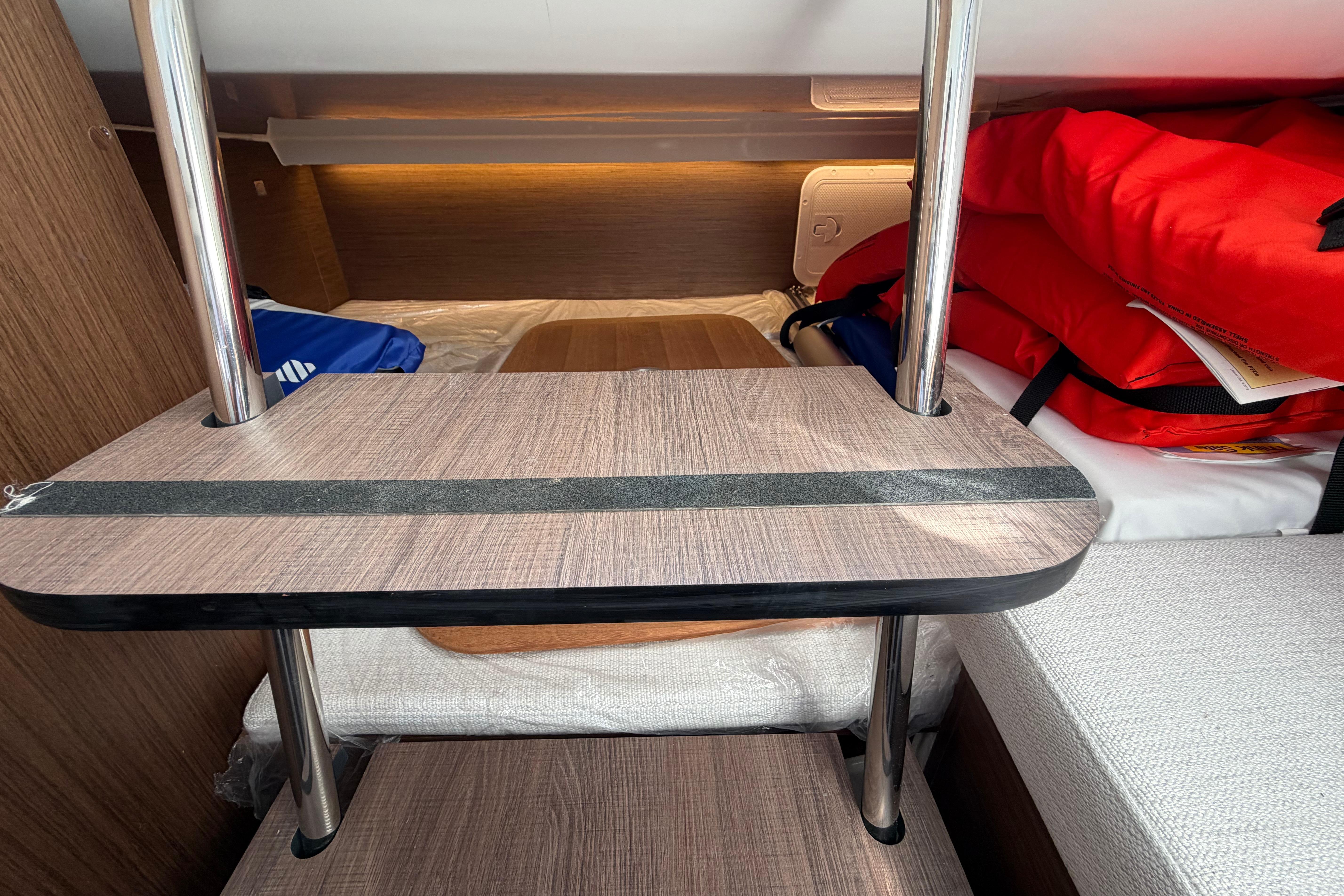 2024 Jeanneau Leader 9.0 CC cabin interior with wooden table and life jackets.