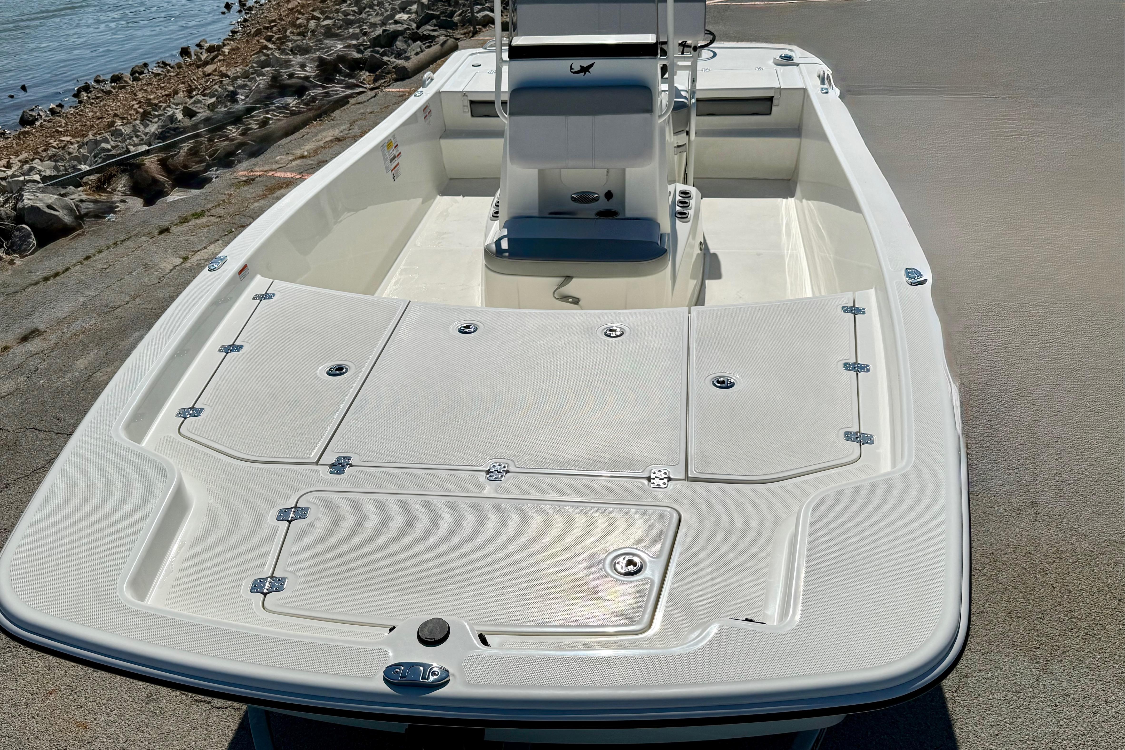 2024 Mako Pro Skiff 19 CC boat on a concrete surface near water.