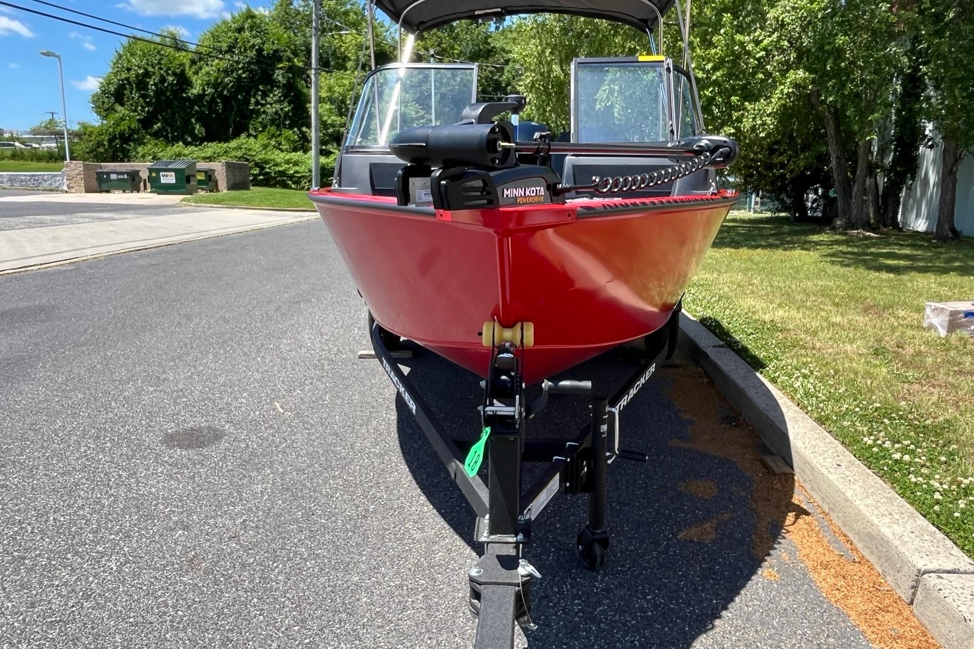 2026 Tracker Pro Guide V-16 WT boat on trailer, parked on sunny street.