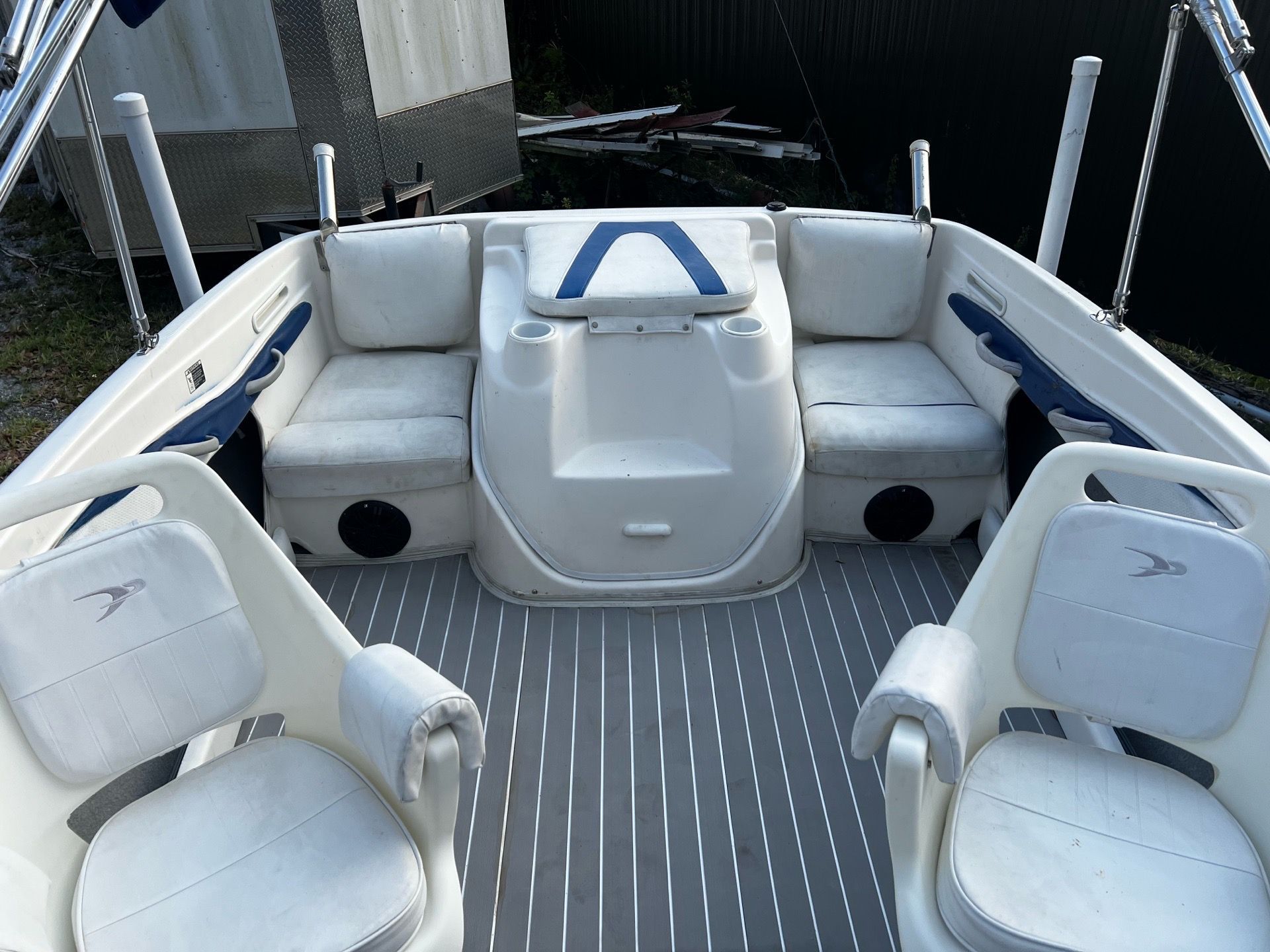 The image shows the cockpit of a 2006 Bayliner 185 with white seats and a gray floor.
