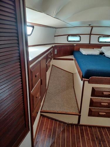 1978 Morgan OutIsland 51 yacht cabin with wooden interior and blue bedding.