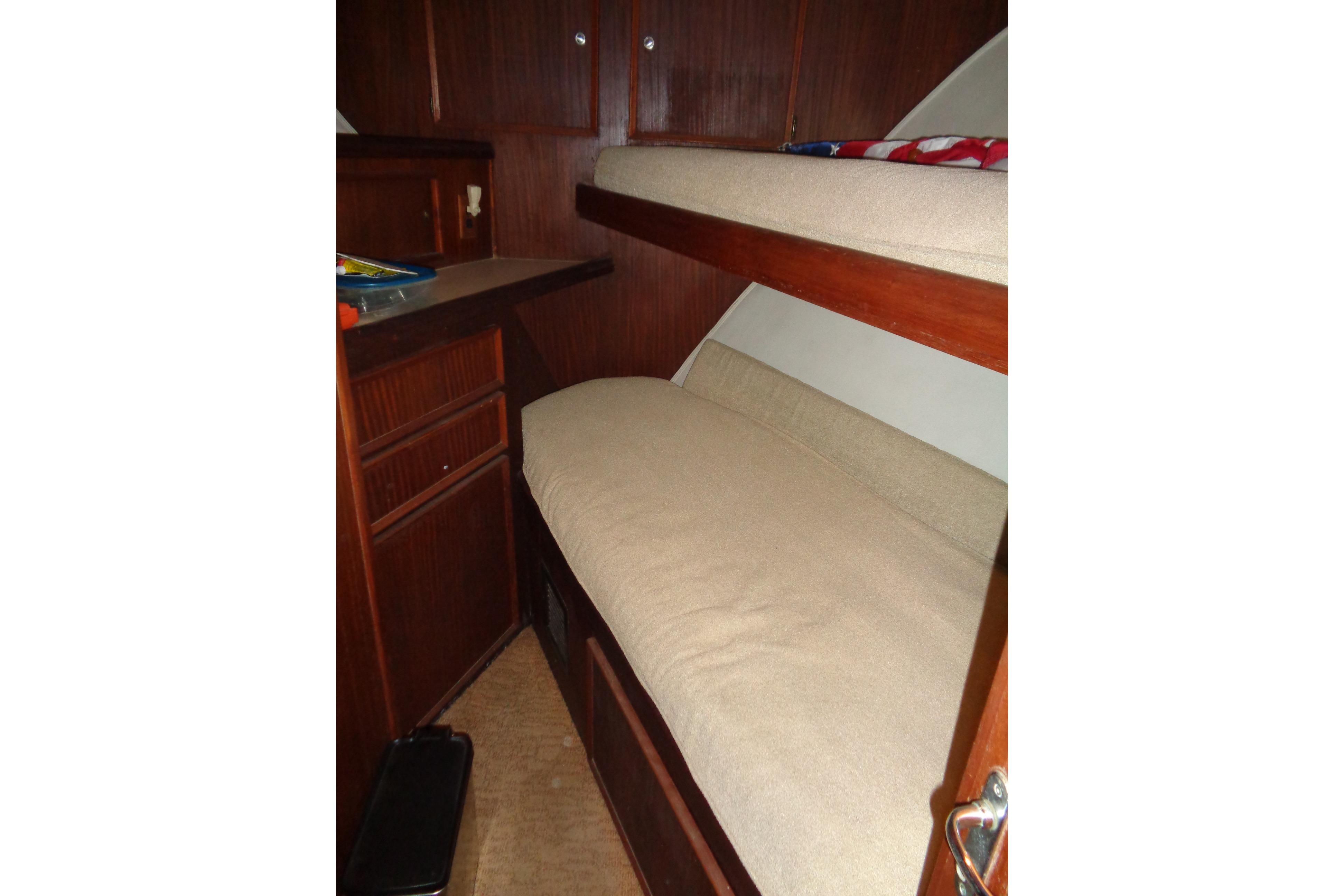 Interior cabin of 1981 Hatteras 48 Cockpit Motor Yacht with bunk beds and wooden cabinetry.