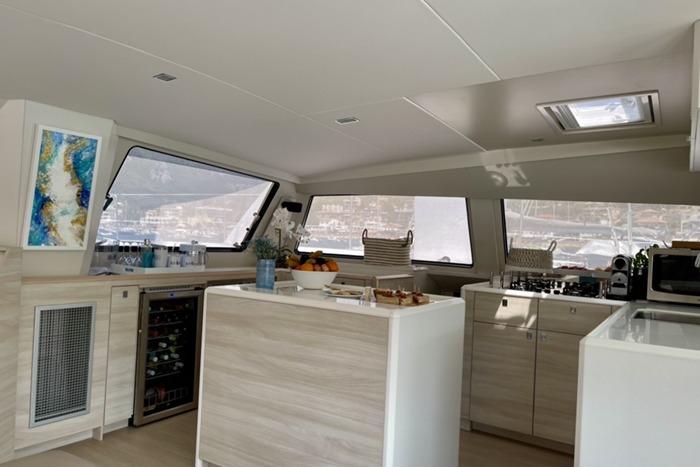Modern kitchen interior of 2021 Catana 53 yacht, featuring sleek design and ample natural light.
