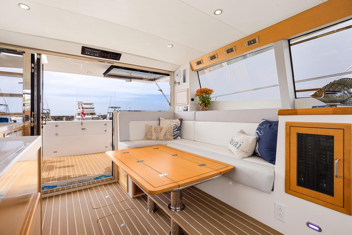 Luxurious interior of 2023 ArrowCat 420 Flybridge yacht with elegant seating and wooden accents.