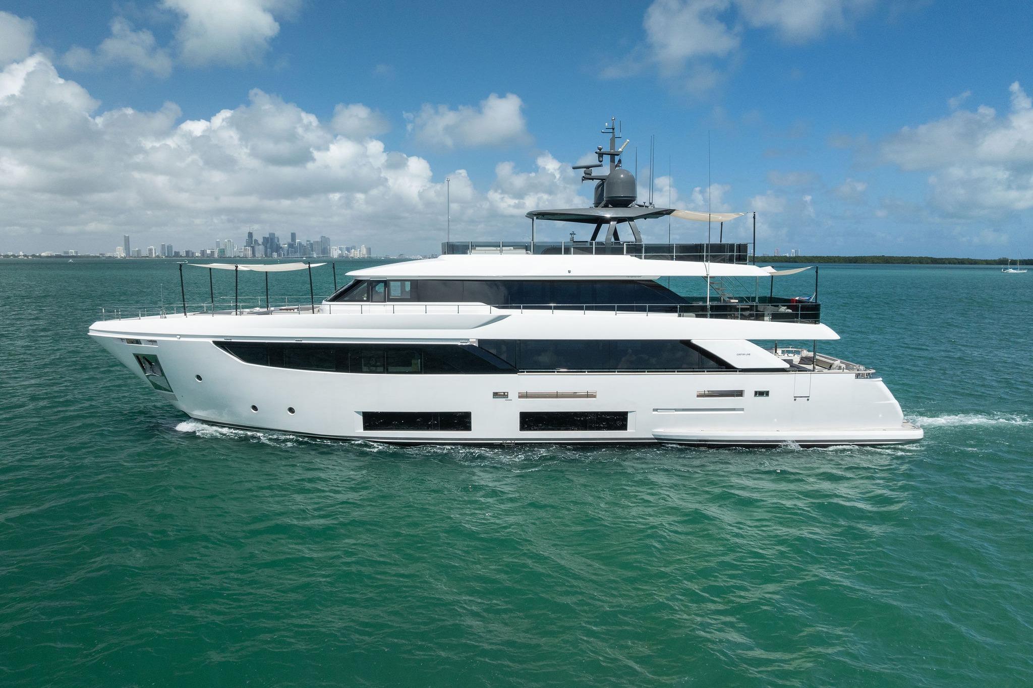 Luxurious 2023 Custom Line Navetta 33 yacht cruising on turquoise waters under a clear sky.