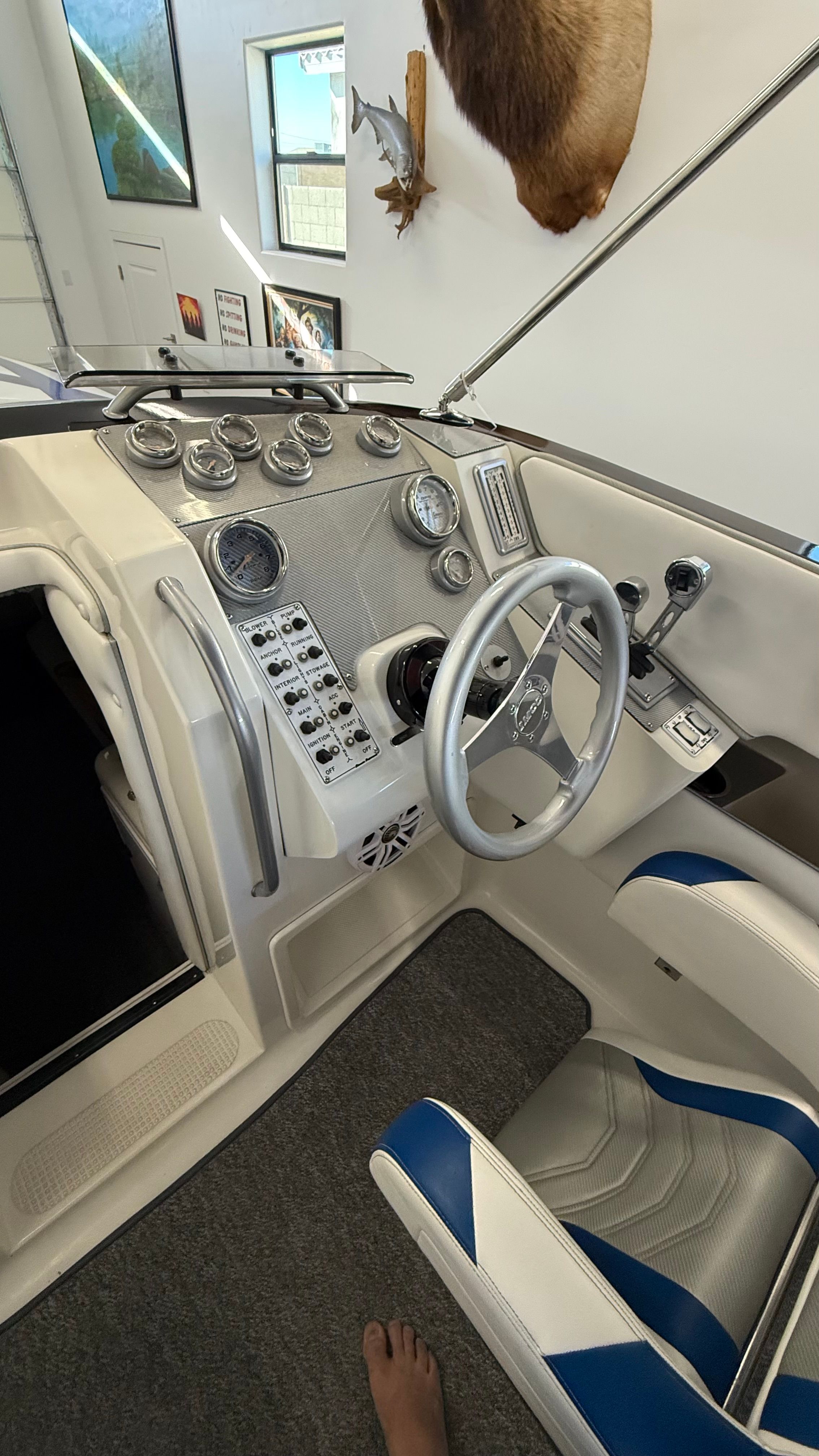 The cockpit of a 1999 Lavey Craft 2950 NuEra with white and blue seats and a helm station.