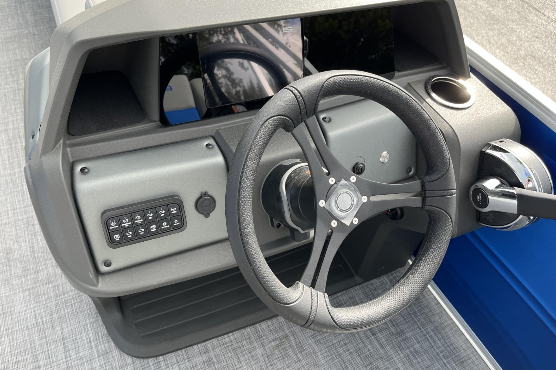 2026 Sun Tracker Party Barge 20 DLX dashboard with steering wheel and control panel.