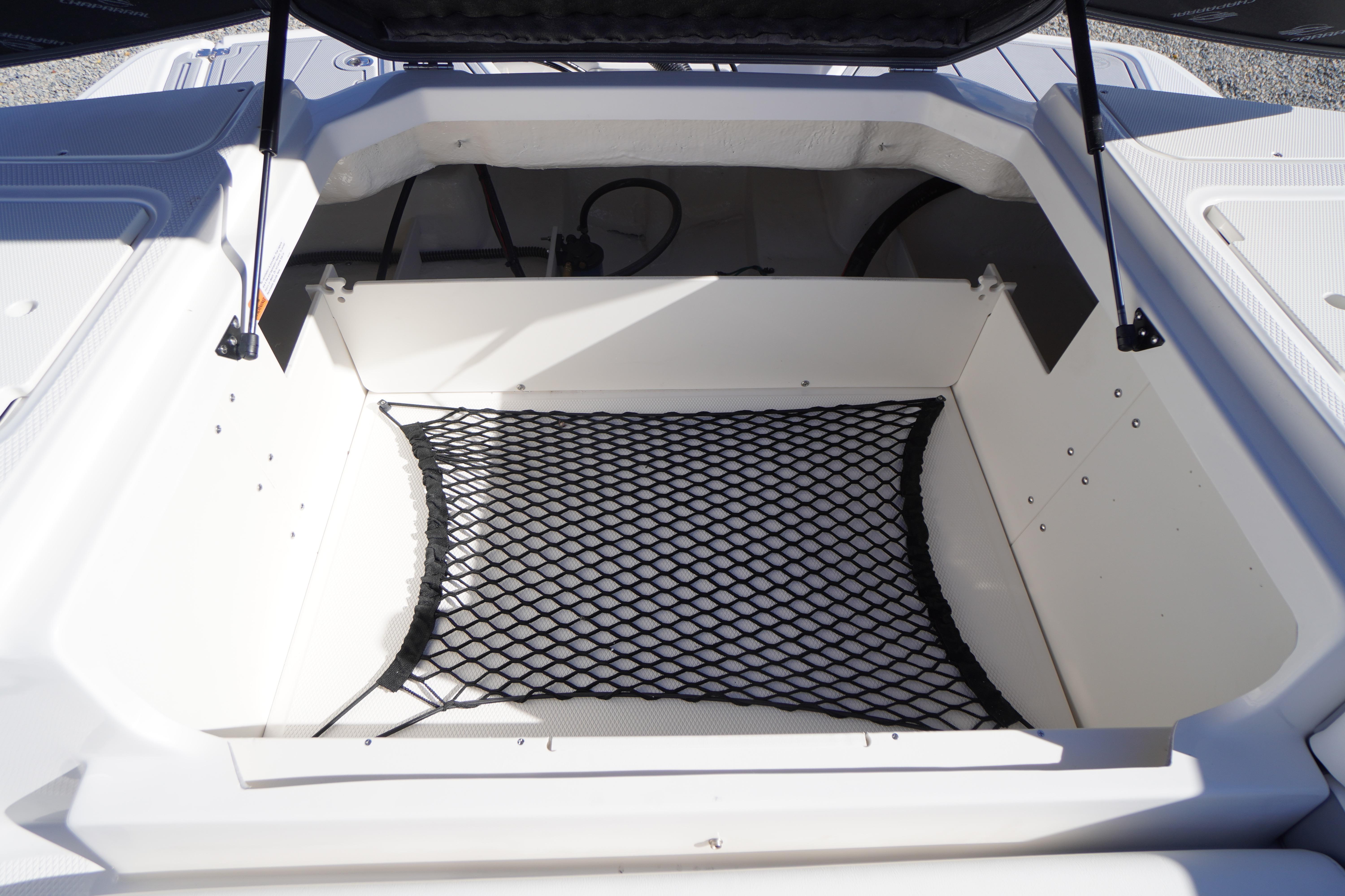 Open storage compartment in 2026 Chaparral 23 SSi OB boat with netting.