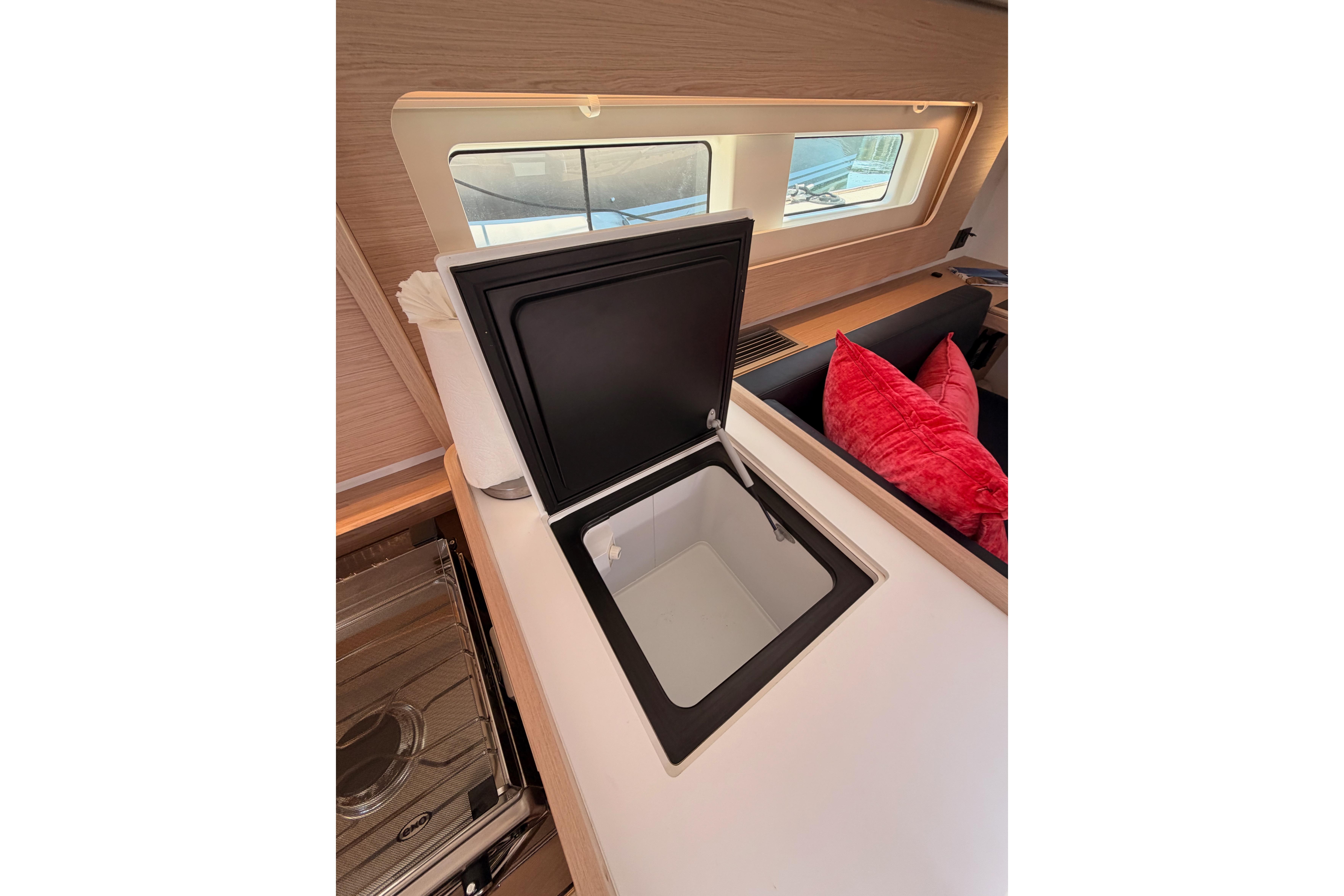 Interior of 2022 Beneteau Oceanis Yacht 54, featuring a sleek kitchen area with open storage.