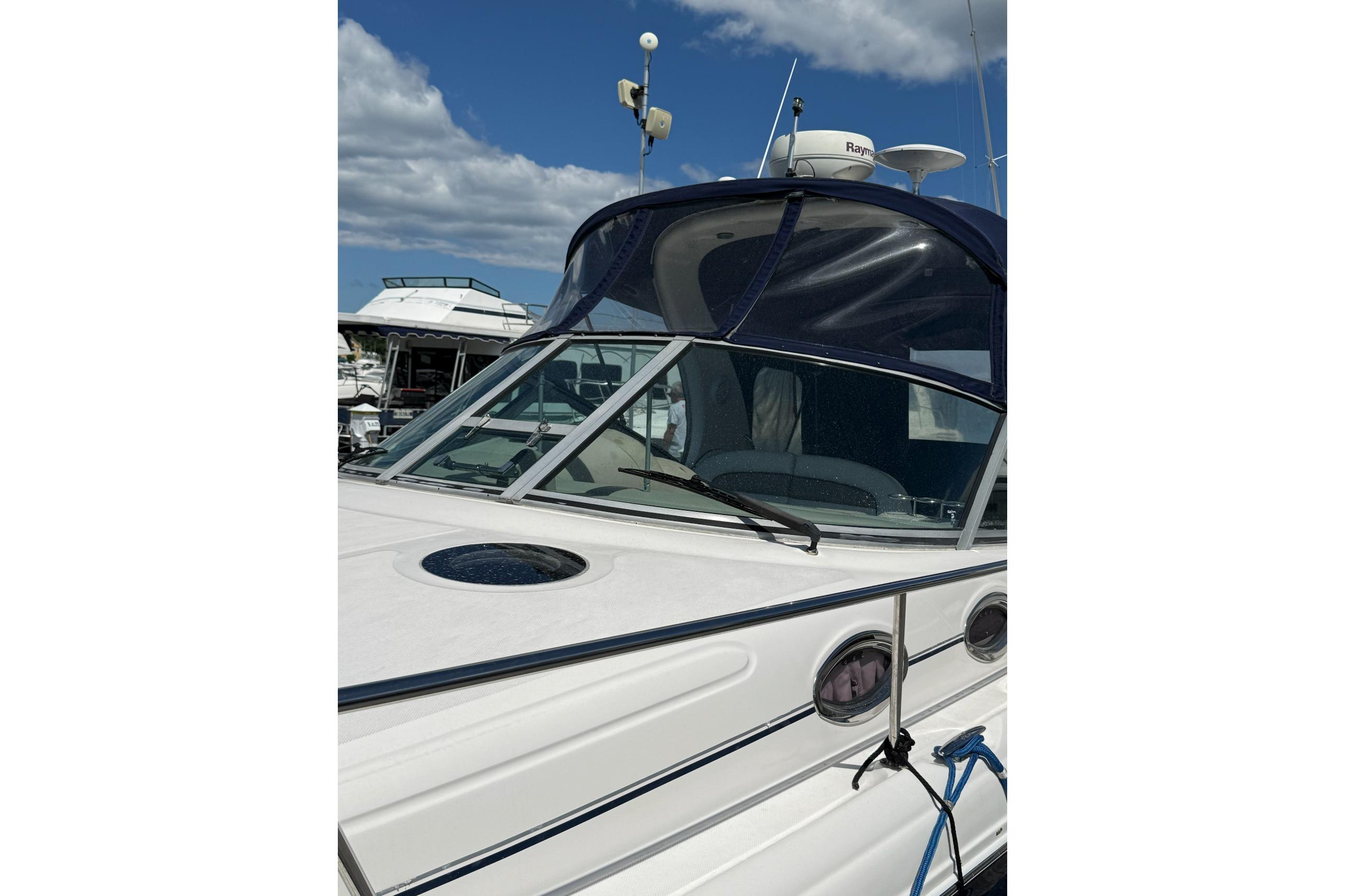 2006 Sea Ray 300 Sundancer boat docked under a clear blue sky.