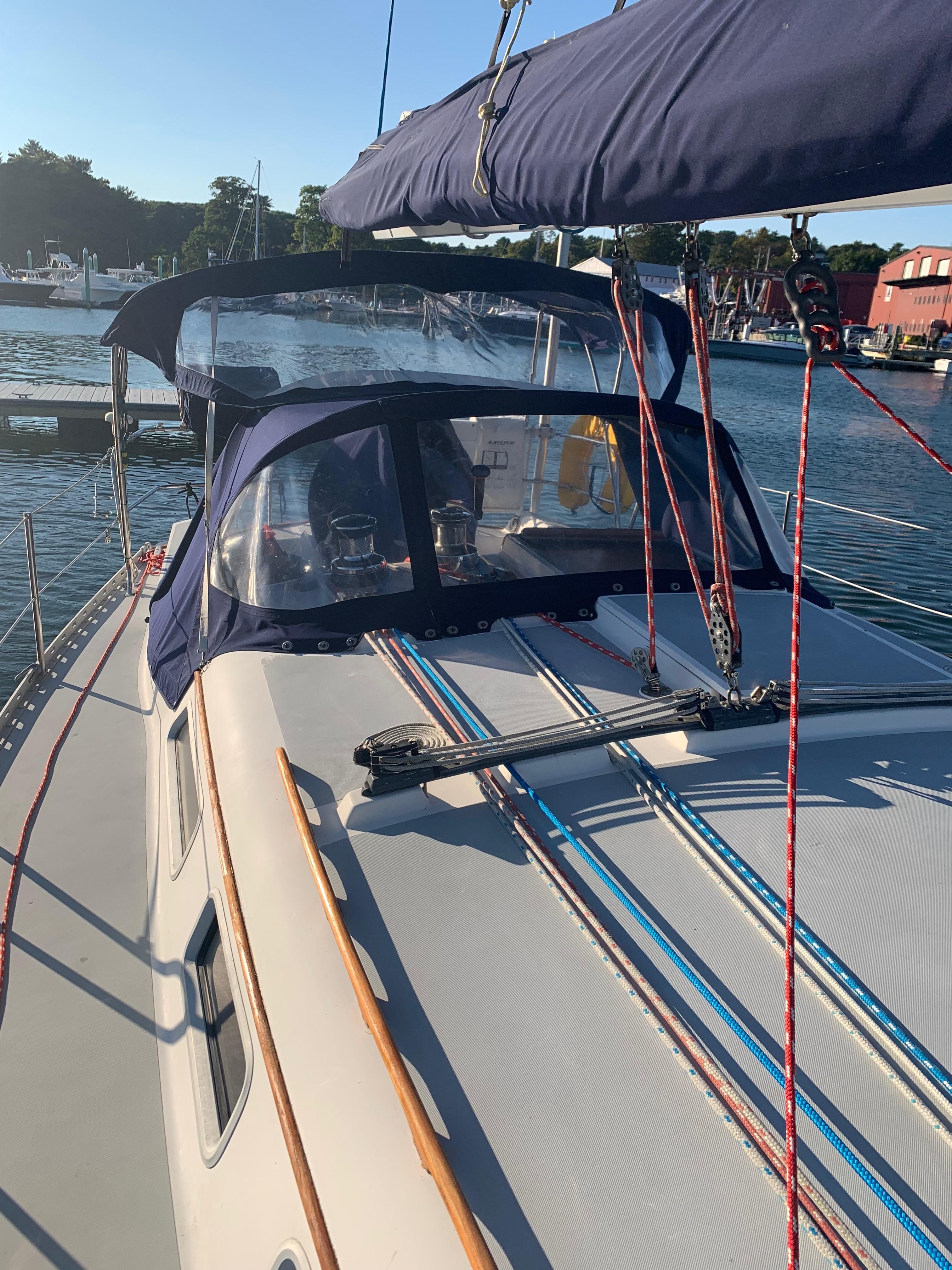1990 Freedom 38 sailboat docked, featuring blue canopy.