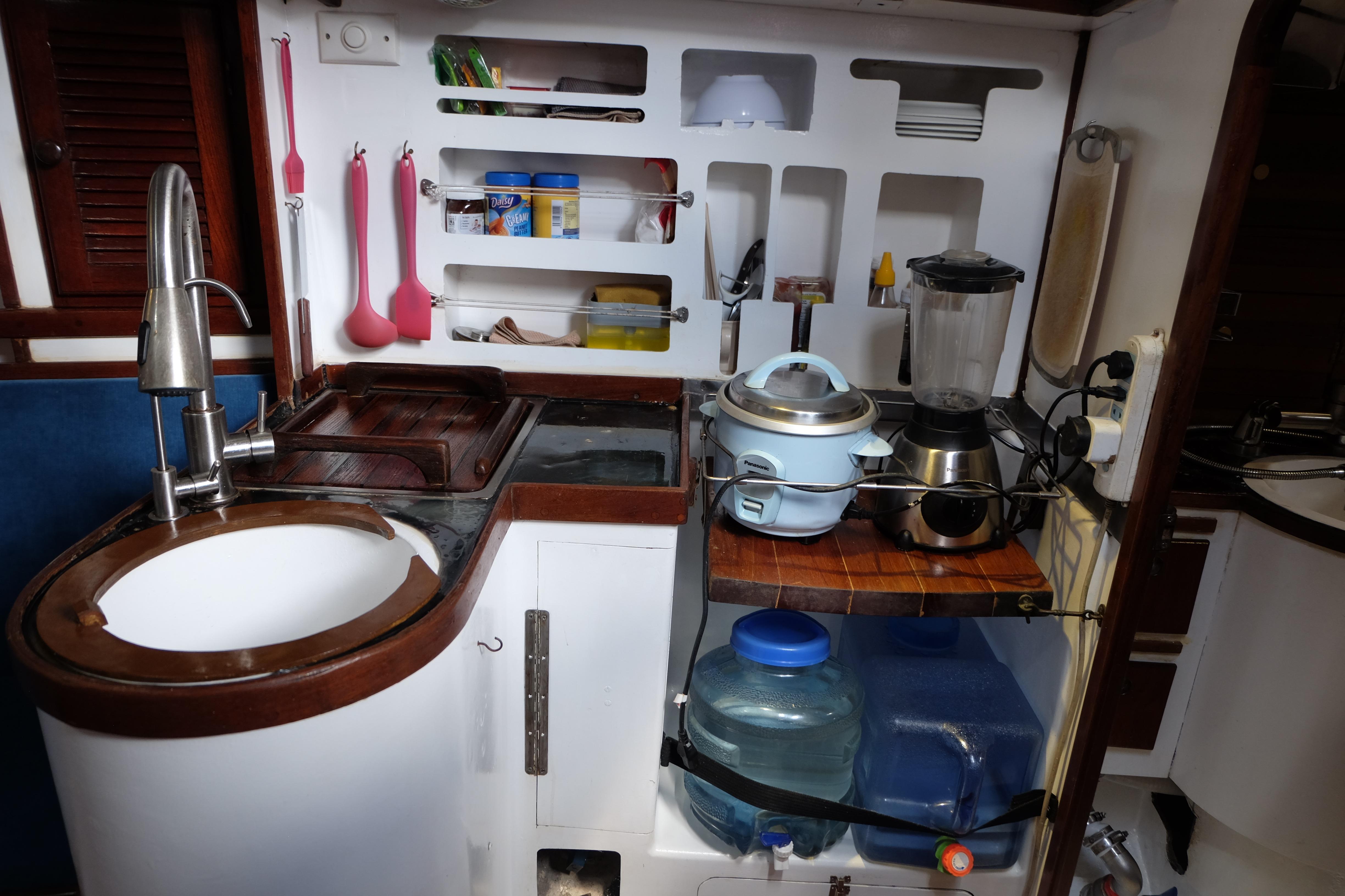 Compact kitchen in a 1986 Martzcraft 35 yacht with sink, appliances, and storage.