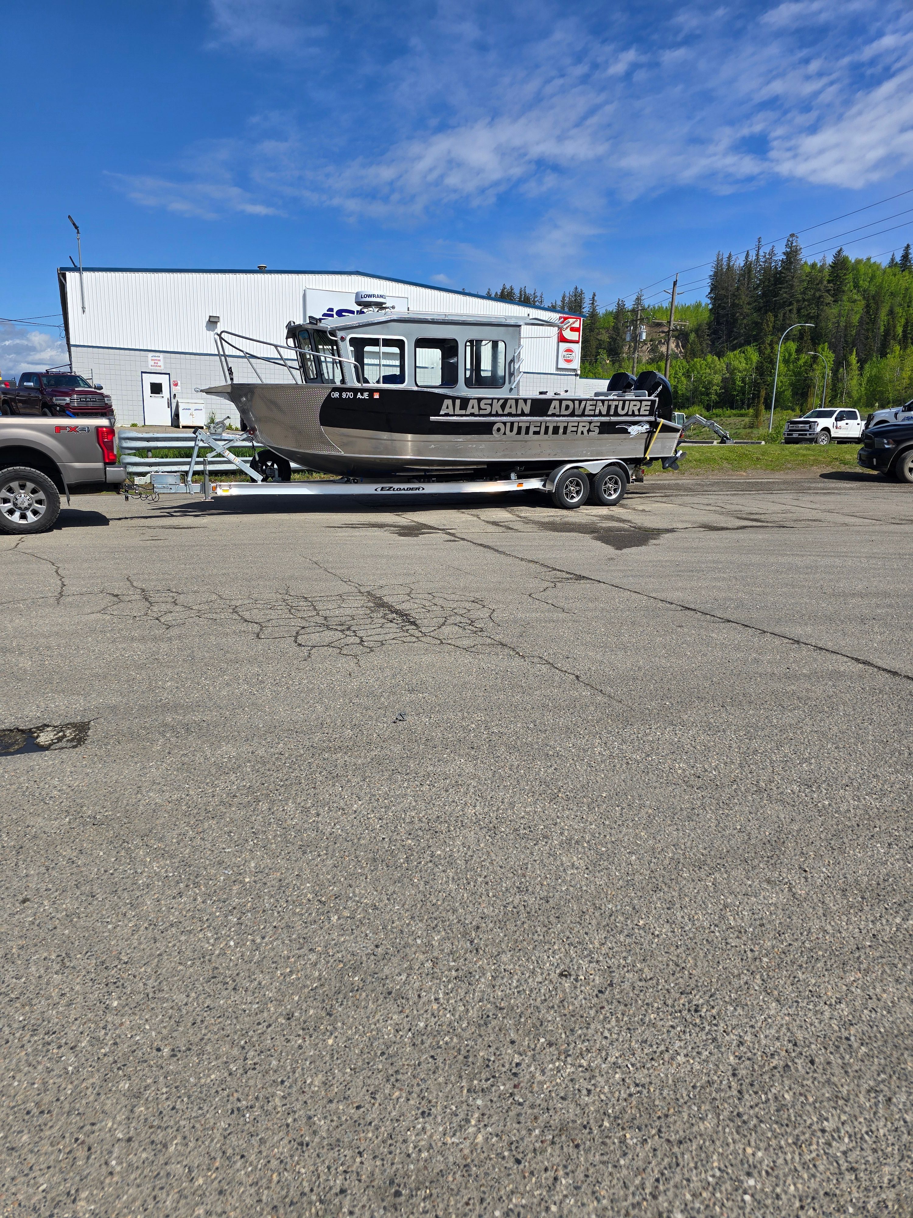 2025 Custom Alaskan Explorer boat on trailer outdoors.