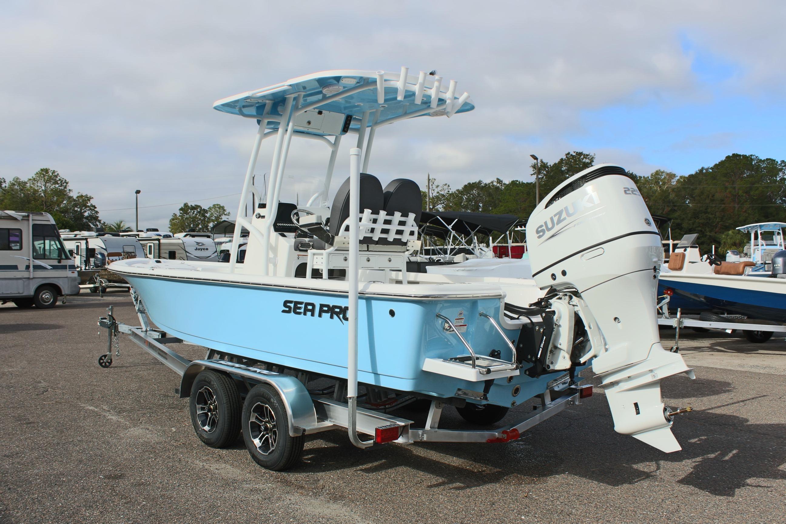 2025 Sea Pro 230 Bay boat with Suzuki engine on a trailer, parked outdoors.