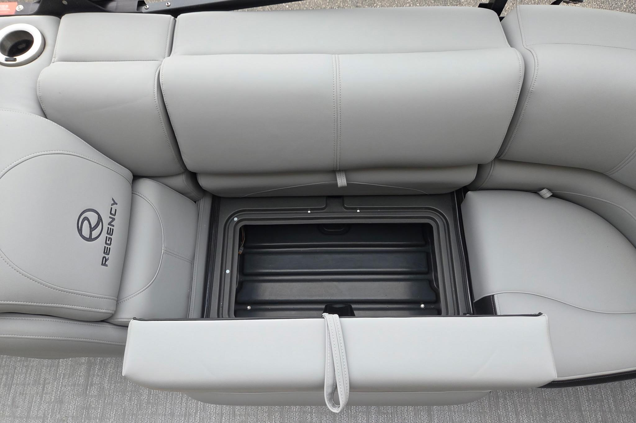 2026 Regency 230 DL boat seat with storage compartment, featuring gray upholstery and cup holder.