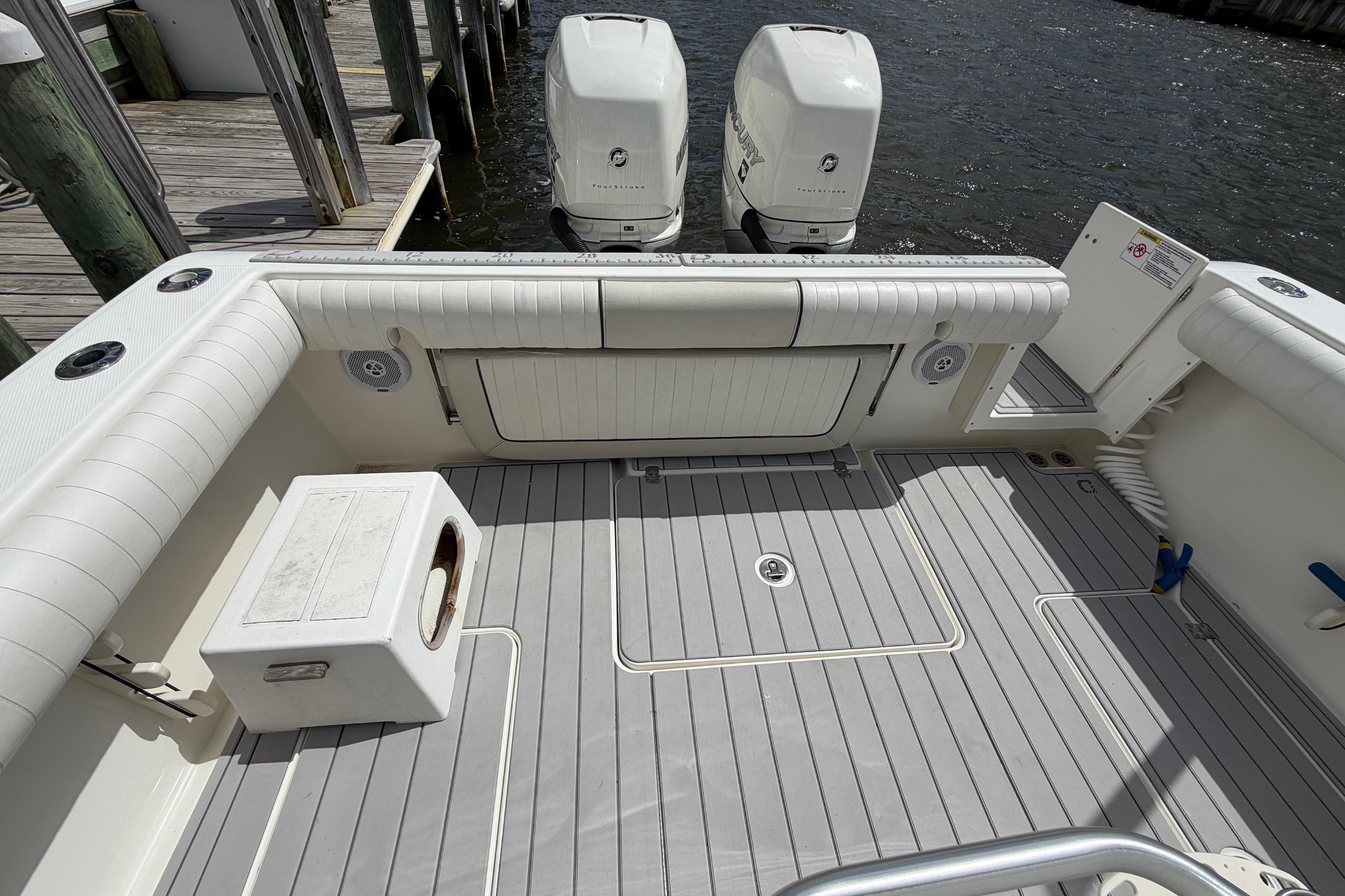 2017 Mako 284 Center Console boat with twin outboard engines at dock.