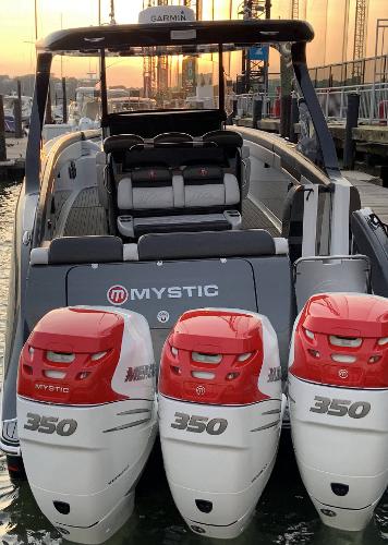2017 Mystic Powerboats M4200 with triple 350 horsepower engines docked at sunset.