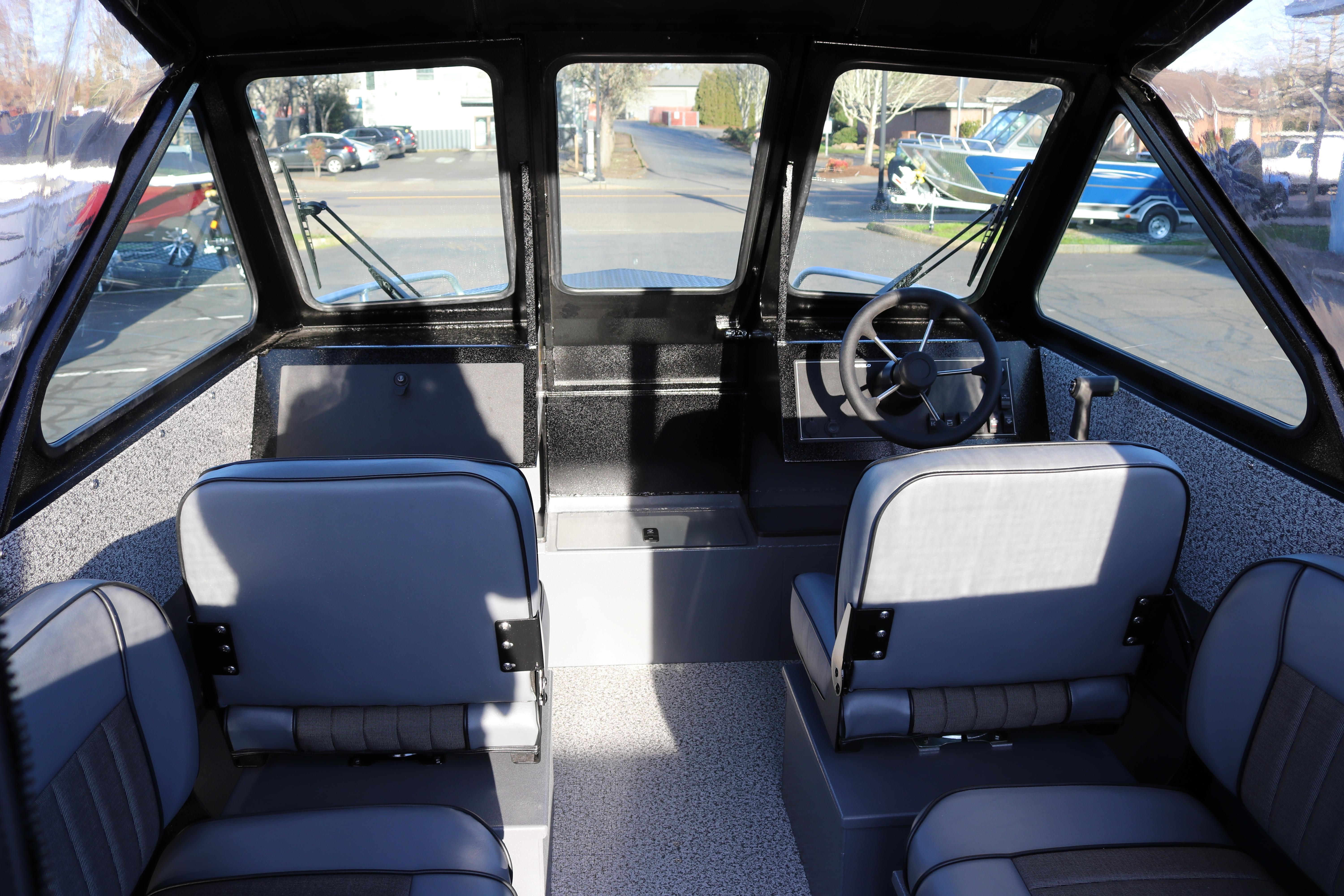 Interior of 2026 Alumaweld Stryker X202 boat with seating and steering wheel.