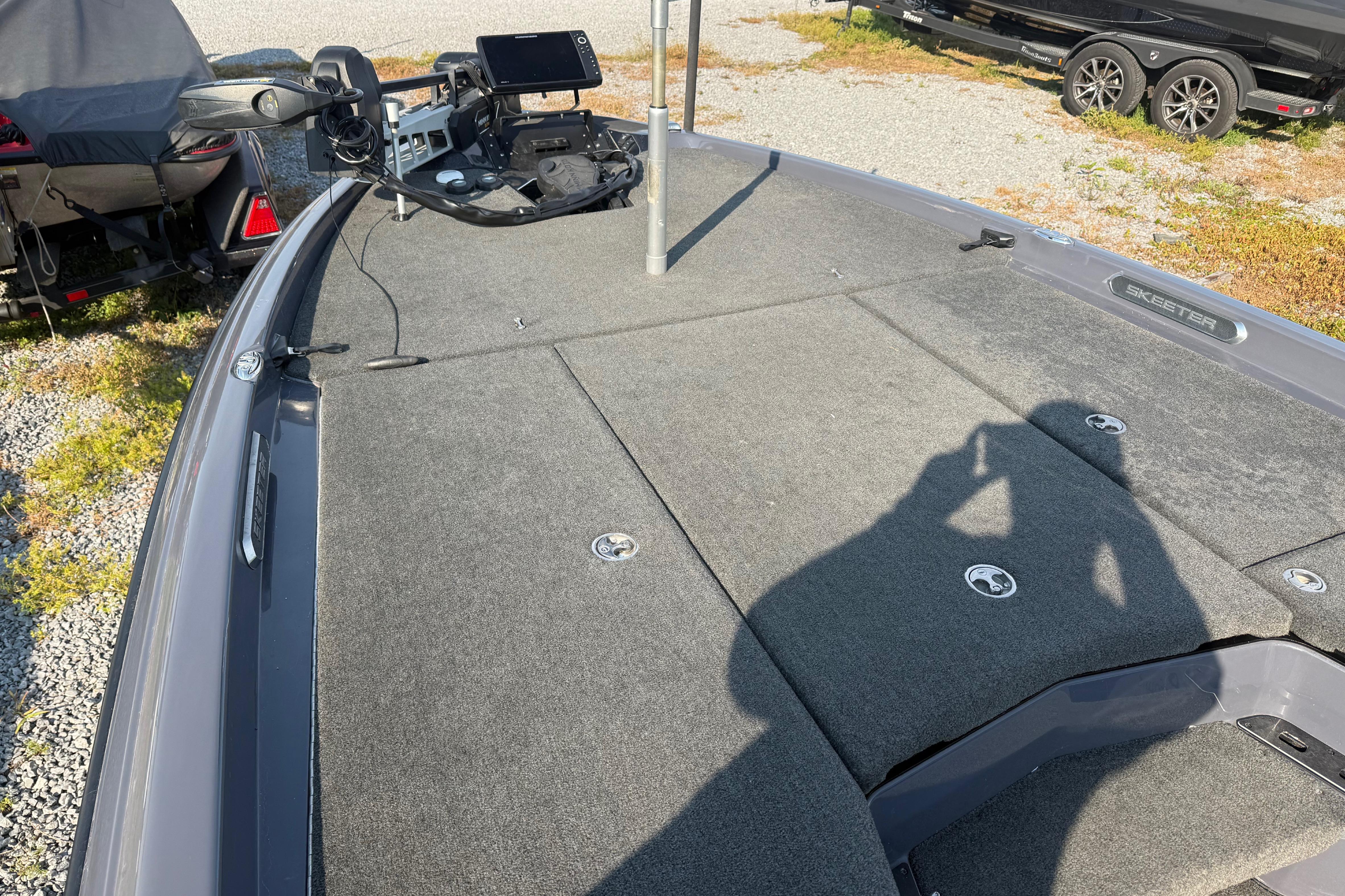 2024 Skeeter FXR21 boat deck with carpeted surface and control panel.