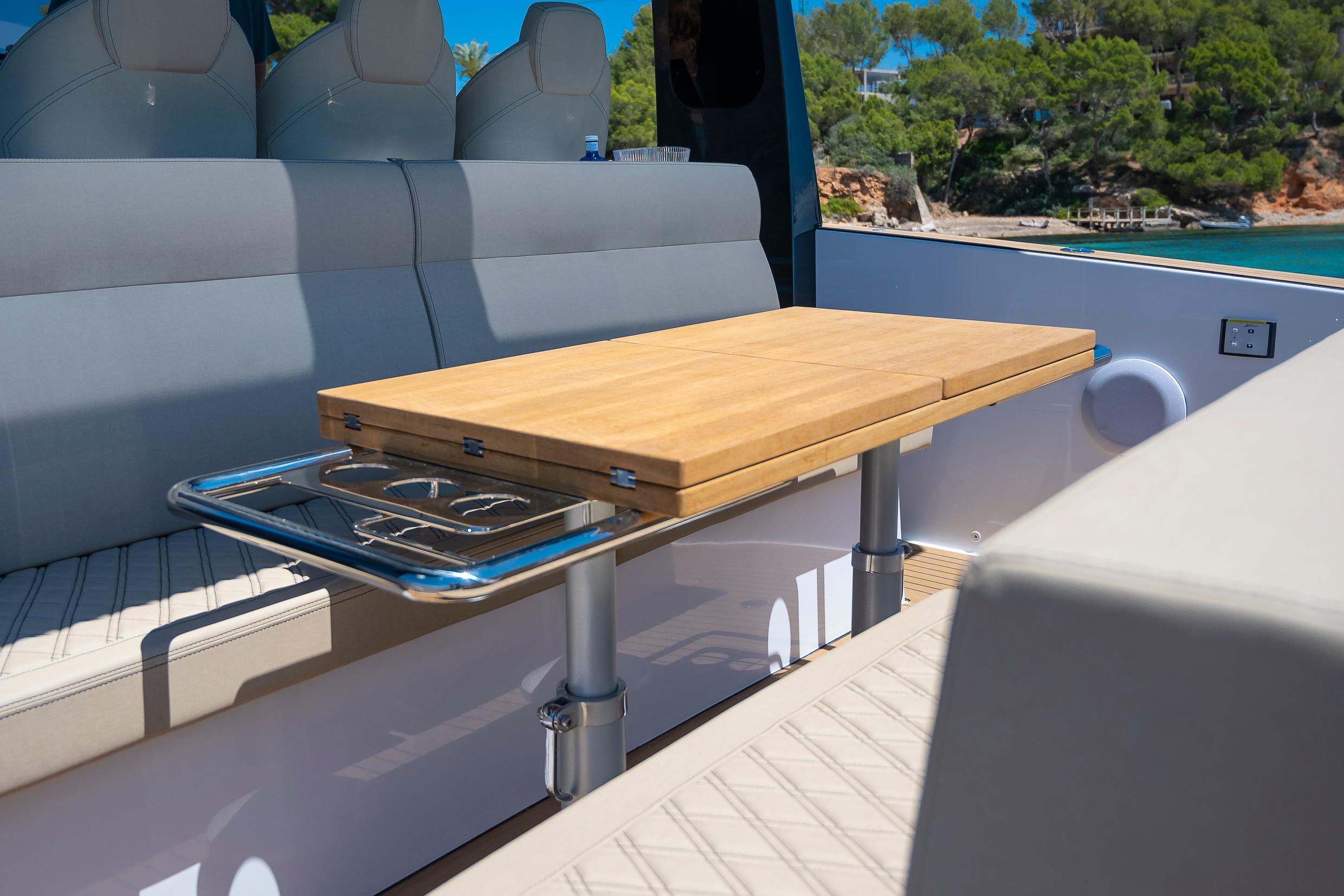 2025 Tesoro T40 Outboard boat interior with wooden table and cushioned seating.