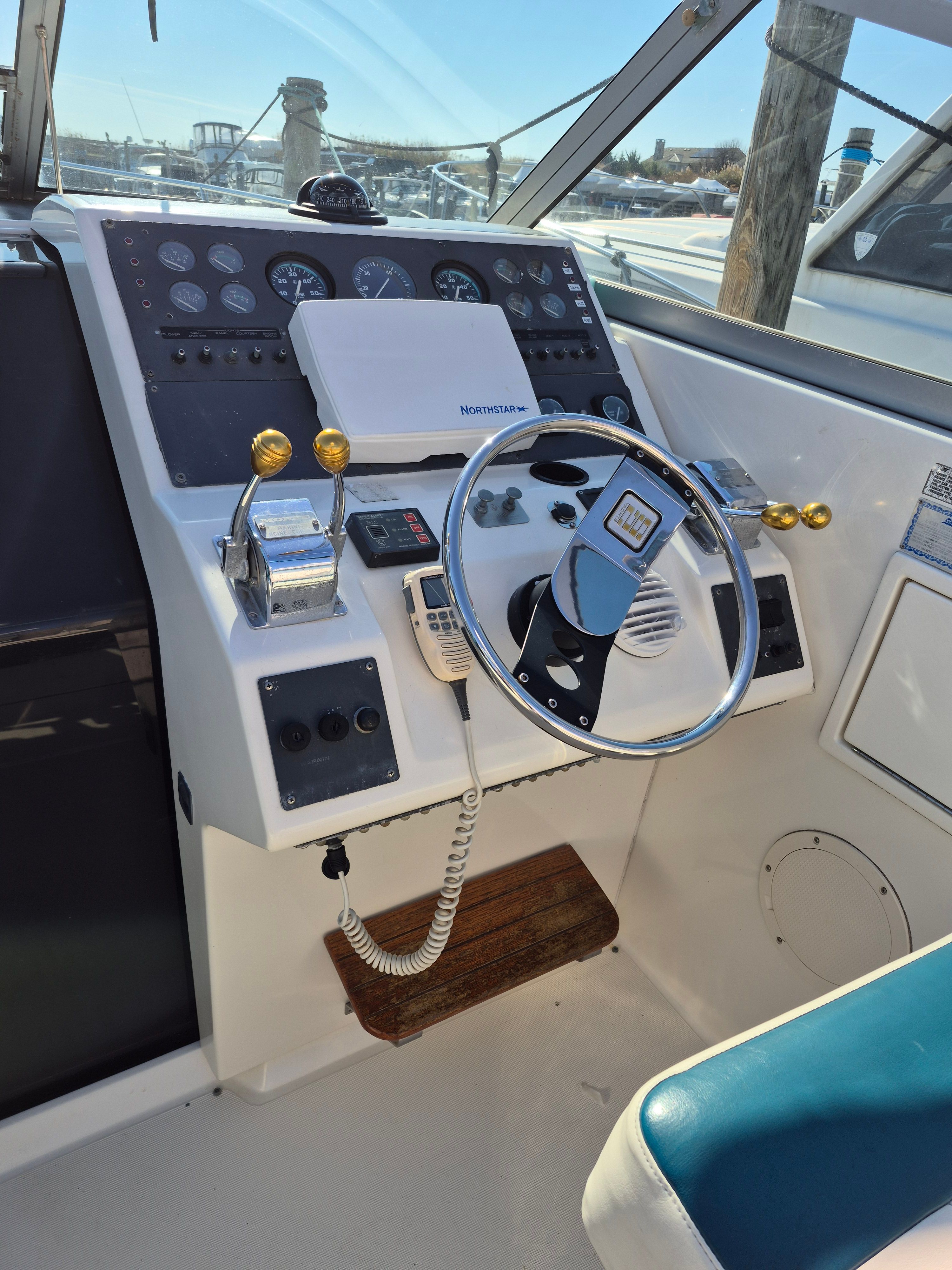 The cockpit of a 1989 Tiara Yachts Slickcraft with steering wheel, instruments, and radio.
