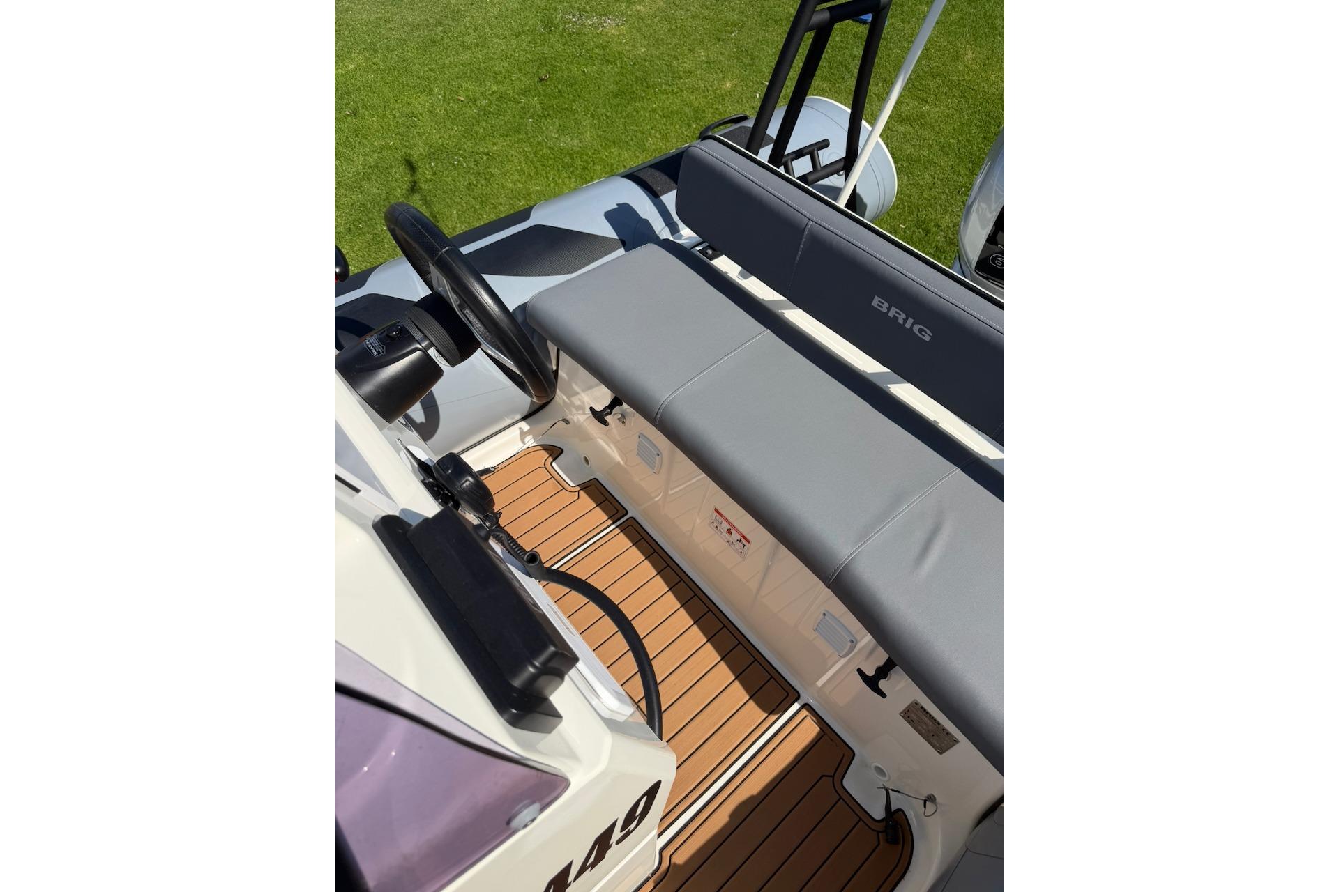 2022 Brig Navigator 485 boat interior with steering wheel and cushioned seating.