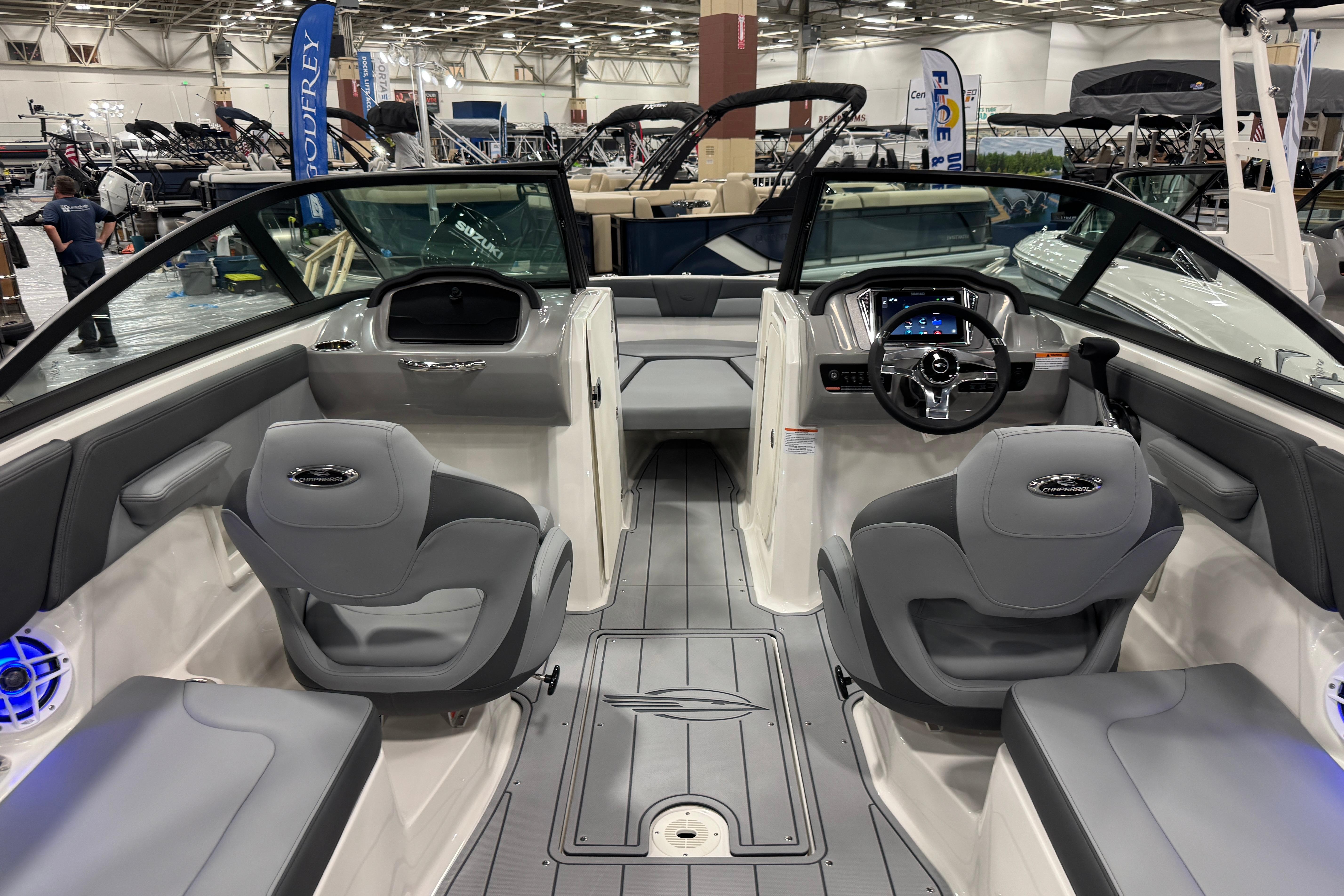 2026 Chaparral 23 SSi boat interior with modern seating and dashboard at a boat show.
