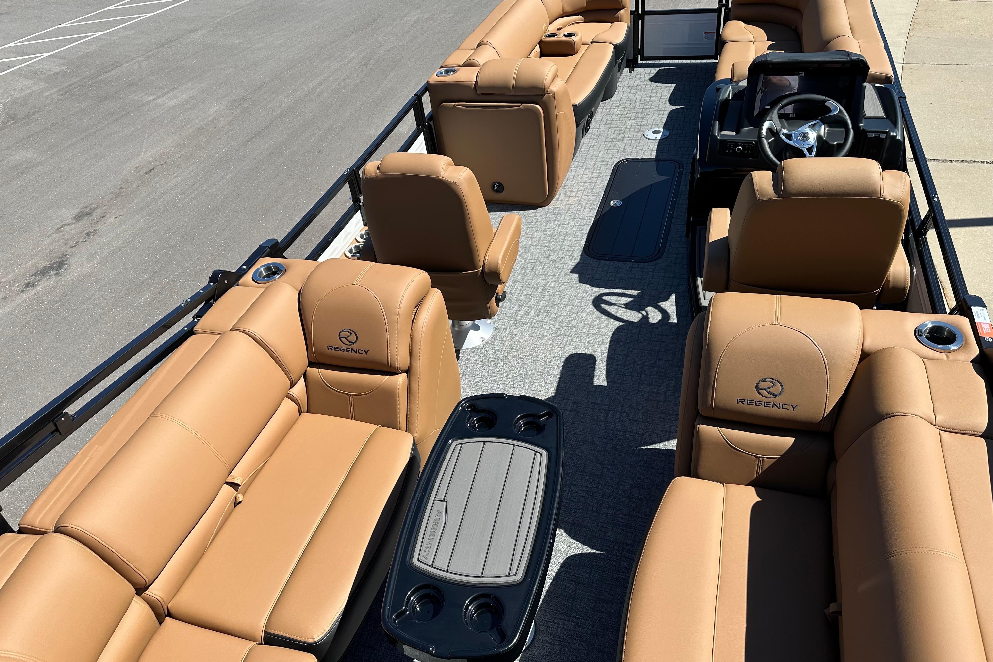 Luxurious 2026 Regency 230 DL pontoon boat with tan leather seating and modern helm.