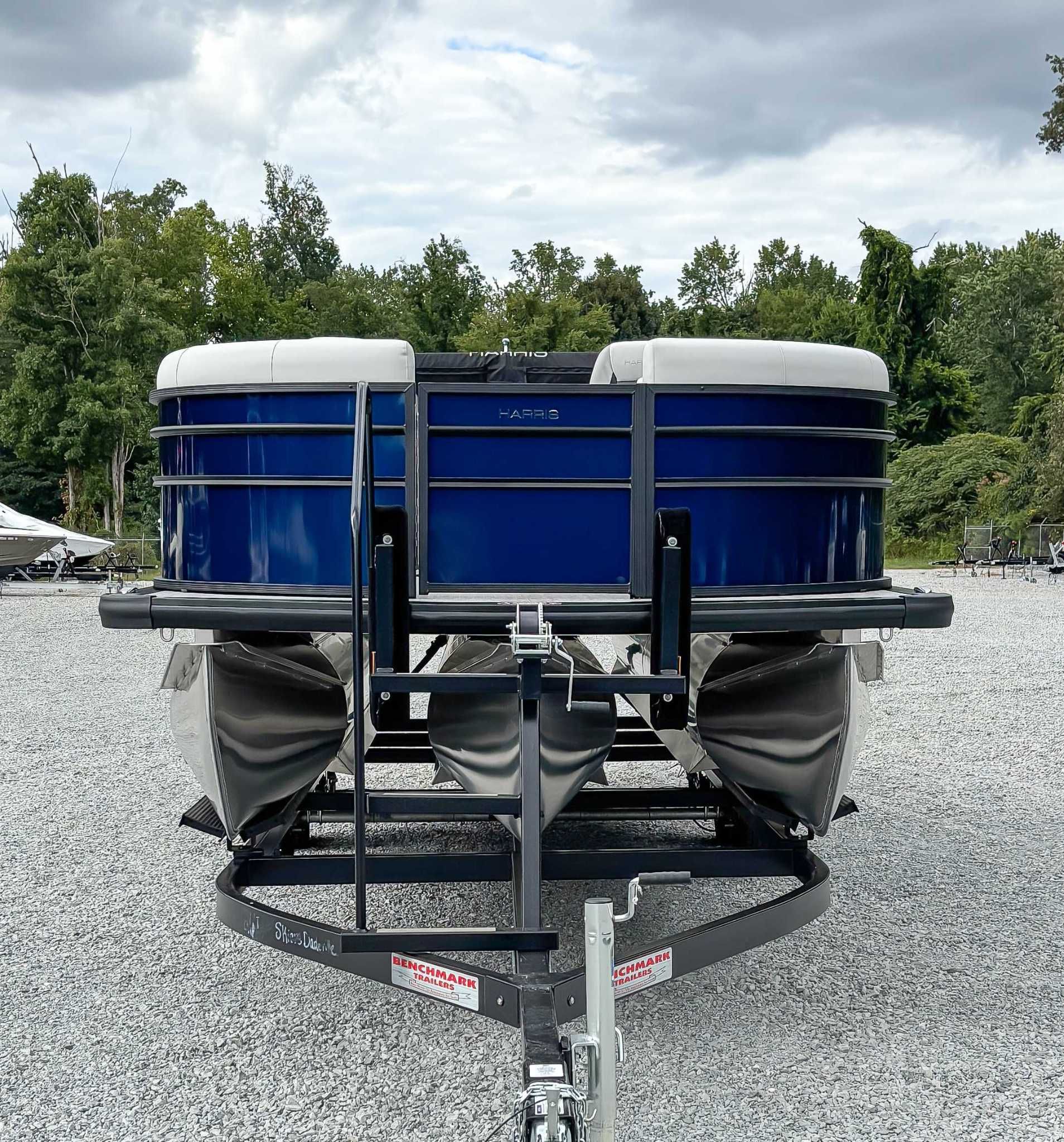 2026 Harris Cruiser 230 SLDH boat on trailer, blue hull, gravel lot.