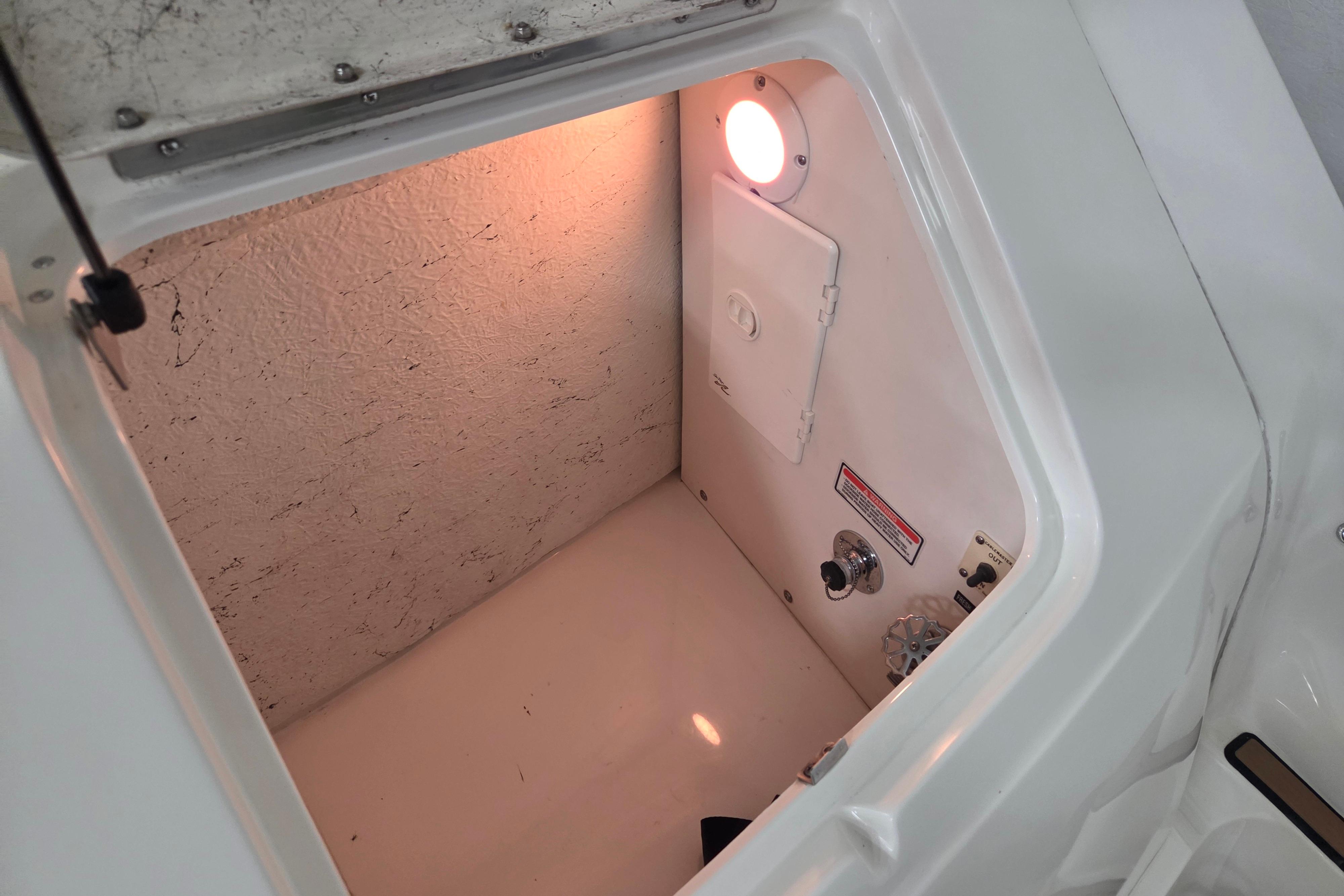Storage compartment inside a 2000 Sea Ray Sundancer 540 boat, featuring a light and control panel.