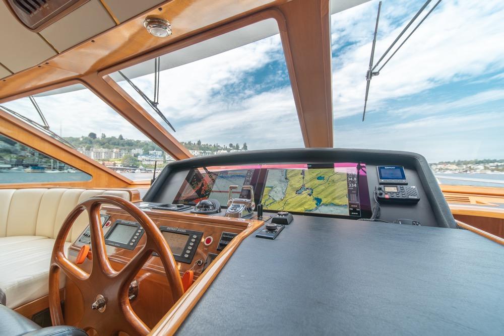 2005 Ocean Alexander 64 Motoryacht helm with navigation screens and wooden steering wheel.