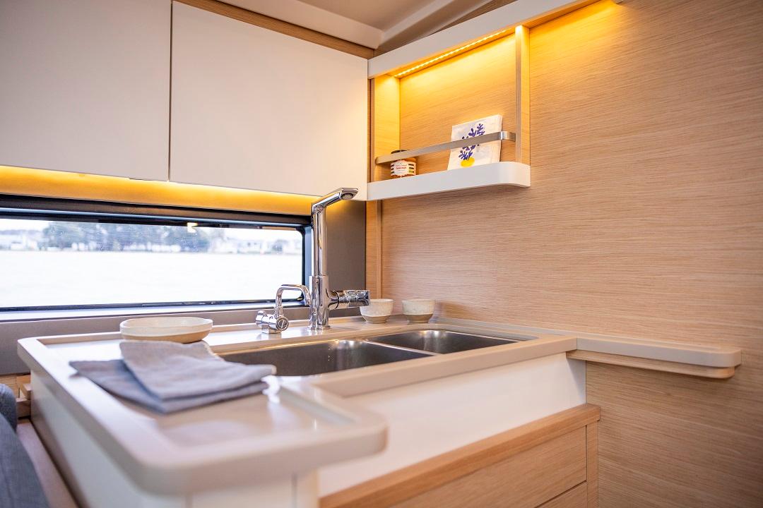 Modern kitchen area in Dufour 44 yacht with sink and wooden cabinetry.