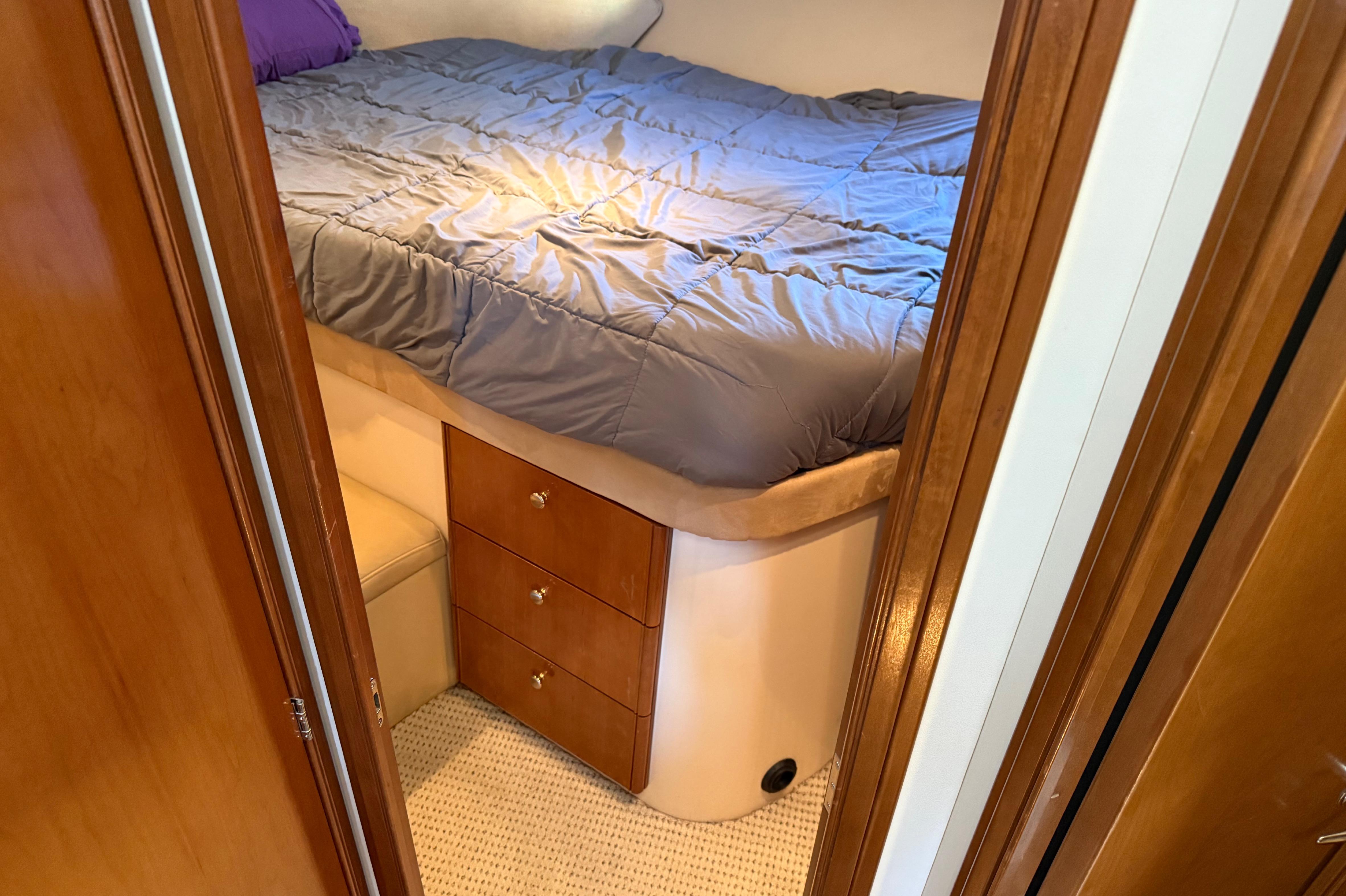 2005 Meridian 341 Sedan cabin interior with bed and wooden drawers.