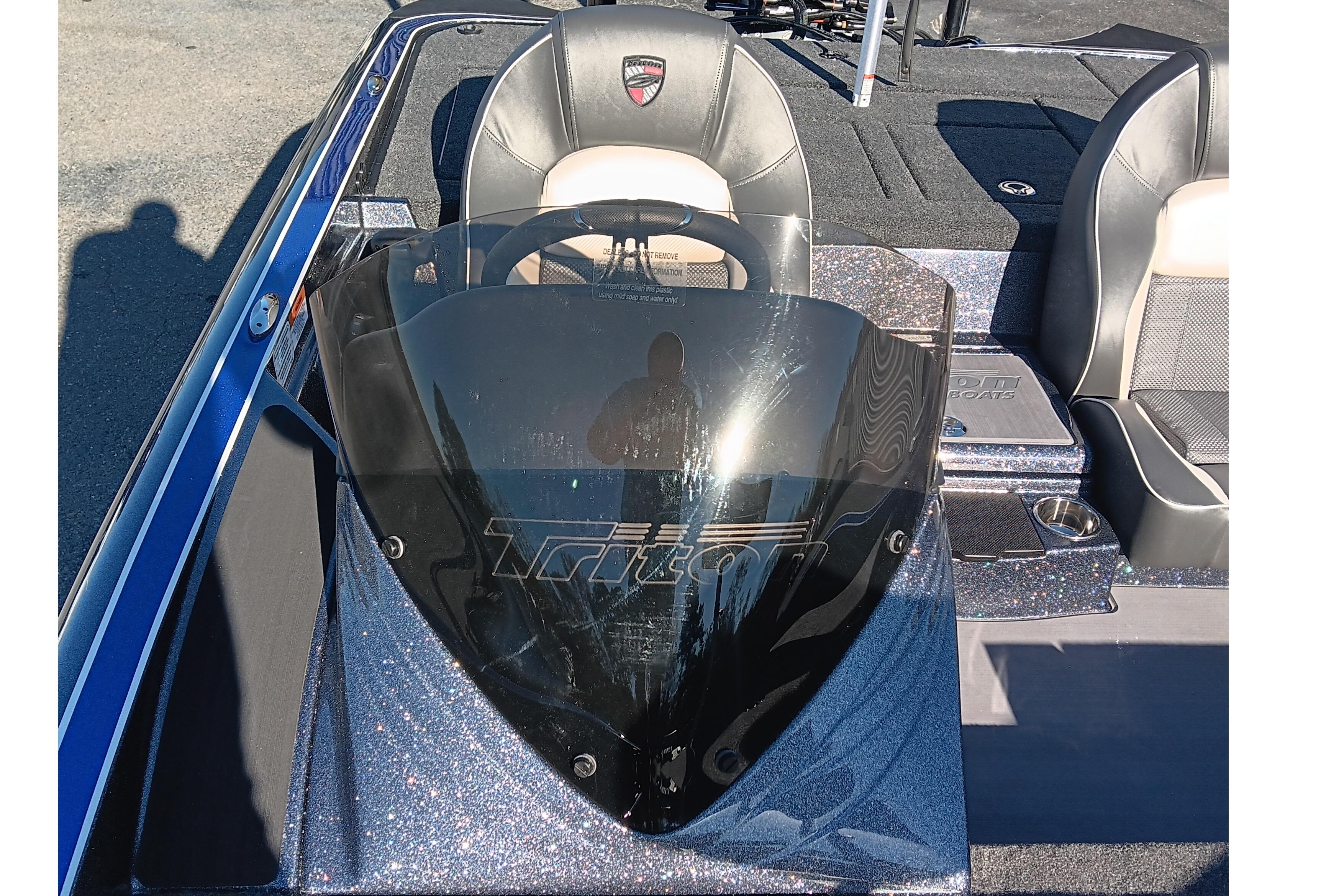 2026 Triton 18 TrX boat cockpit with steering wheel and seats, featuring a sleek design.