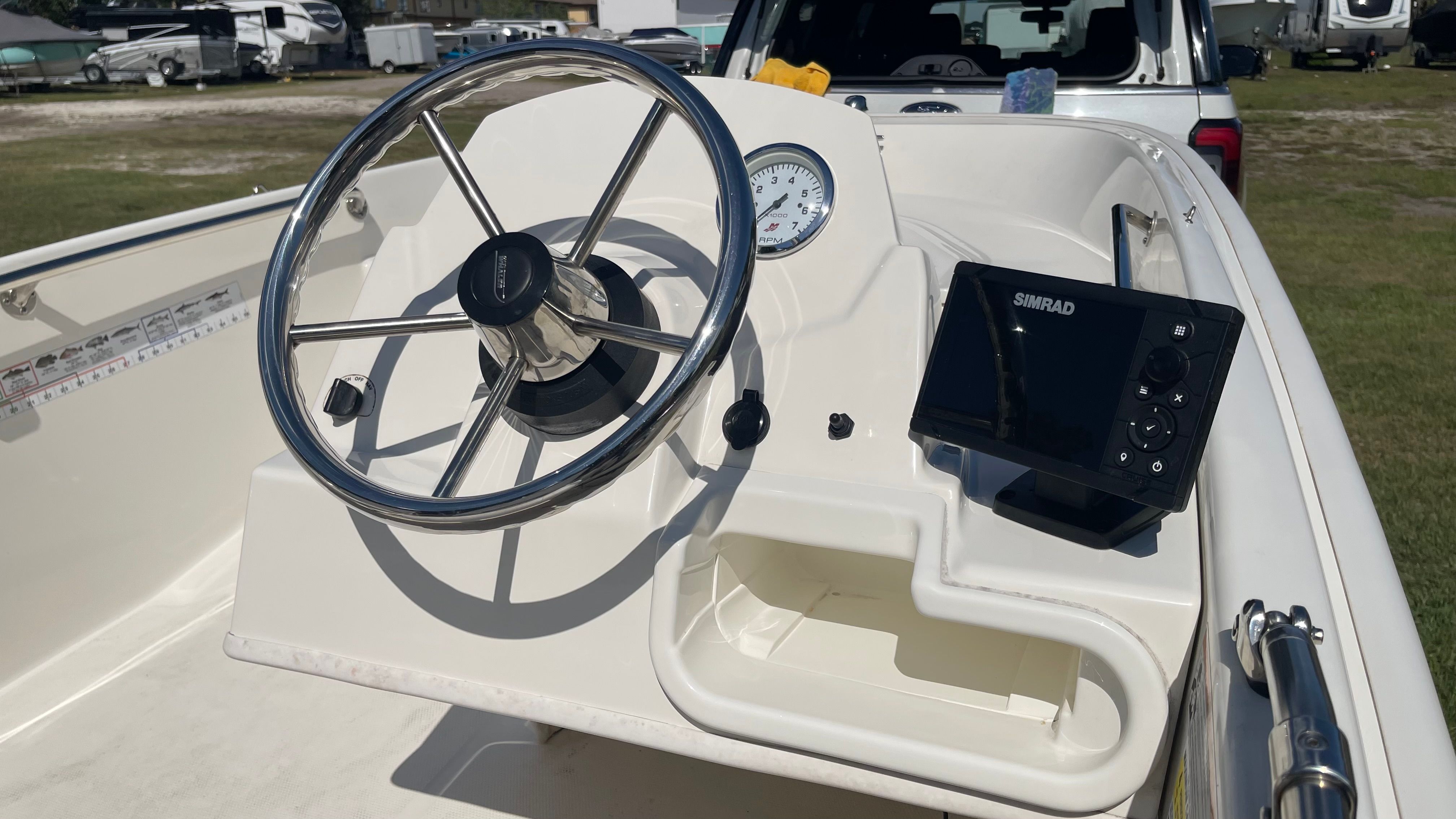 The image shows the helm of a 2017 Boston Whaler 130 Super Sport with a steering wheel and navigation system.