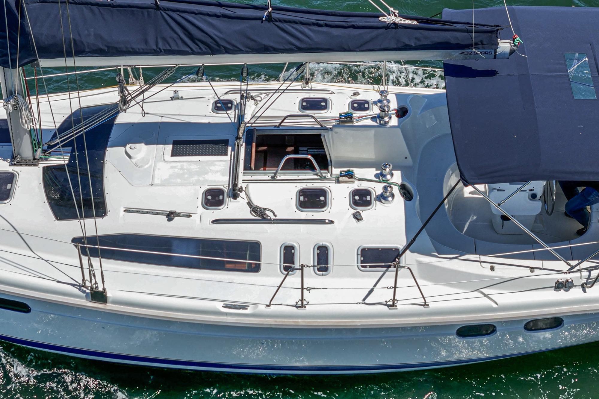 Aerial view of 1996 Hunter 376 sailboat with blue canopy and sleek deck design.