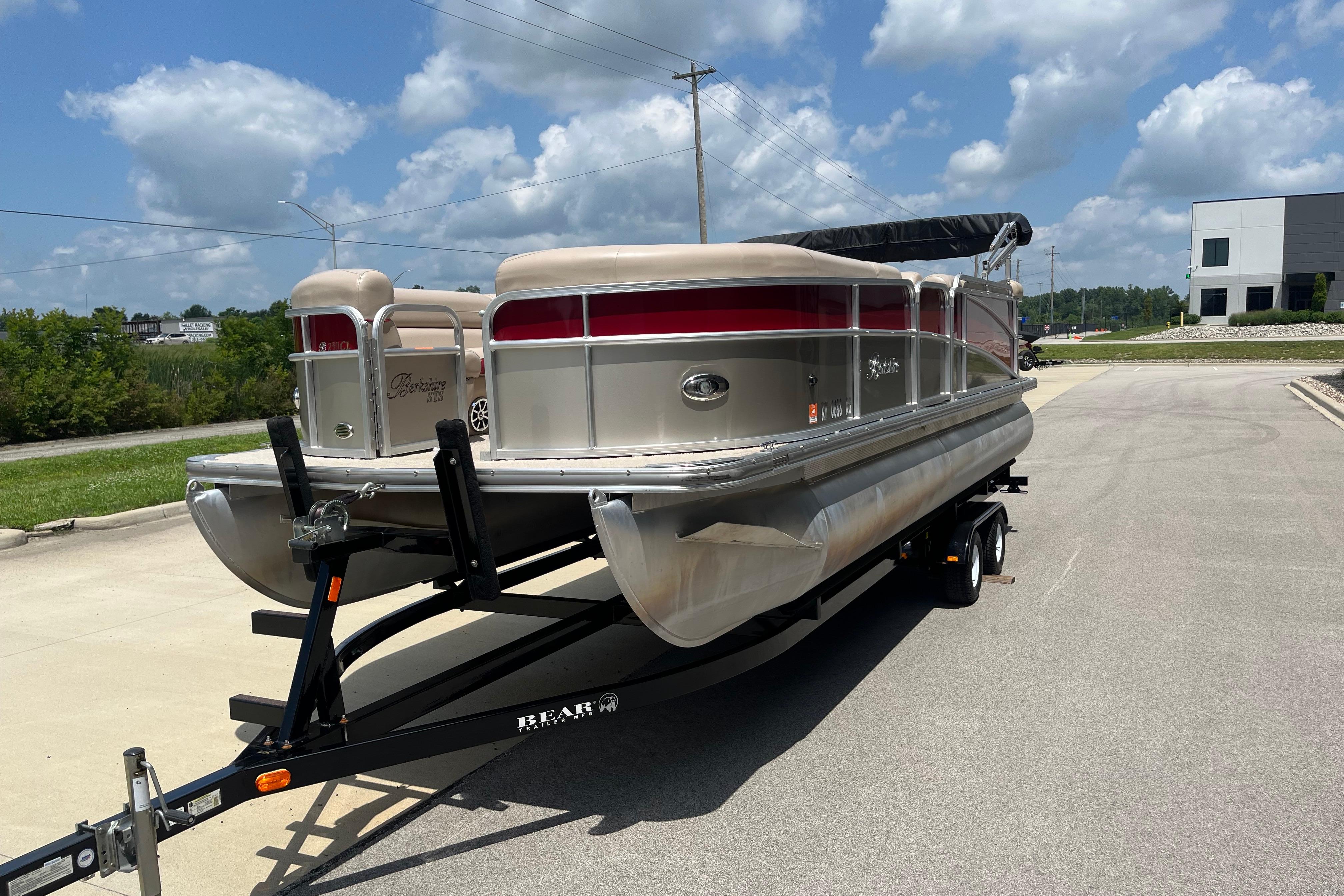 2013 Berkshire 230CL CTS pontoon boat on trailer under a sunny sky.