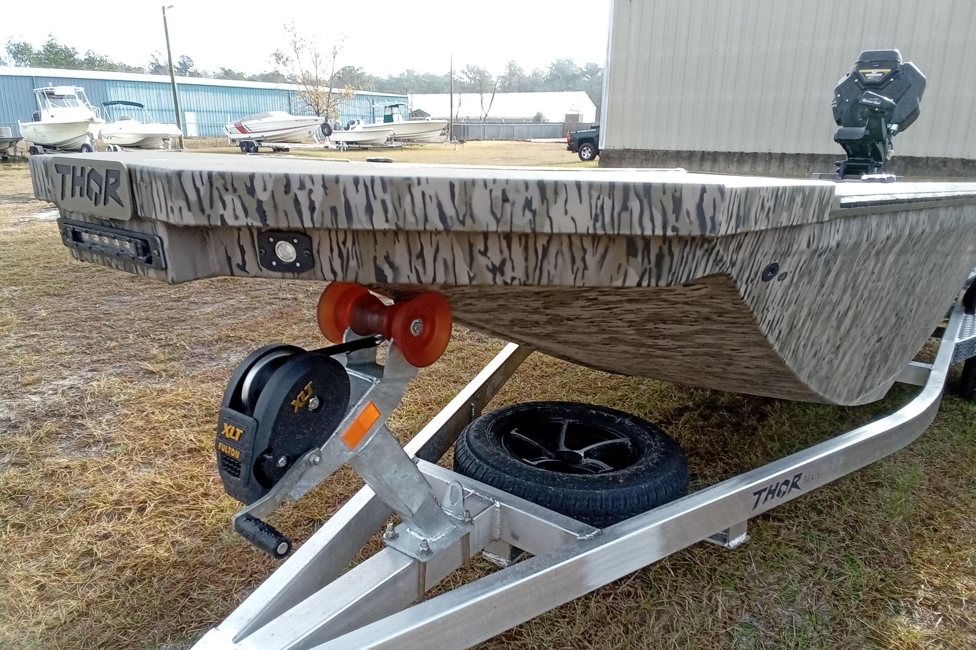 2026 Thor 1754 Swamp Hammer boat on trailer, camo design, outdoor setting.