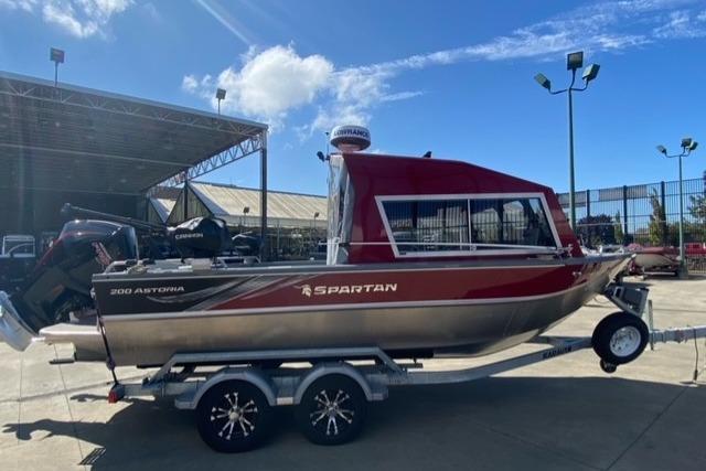 2023 Spartan 200 Astoria boat on trailer, parked outdoors under clear sky.