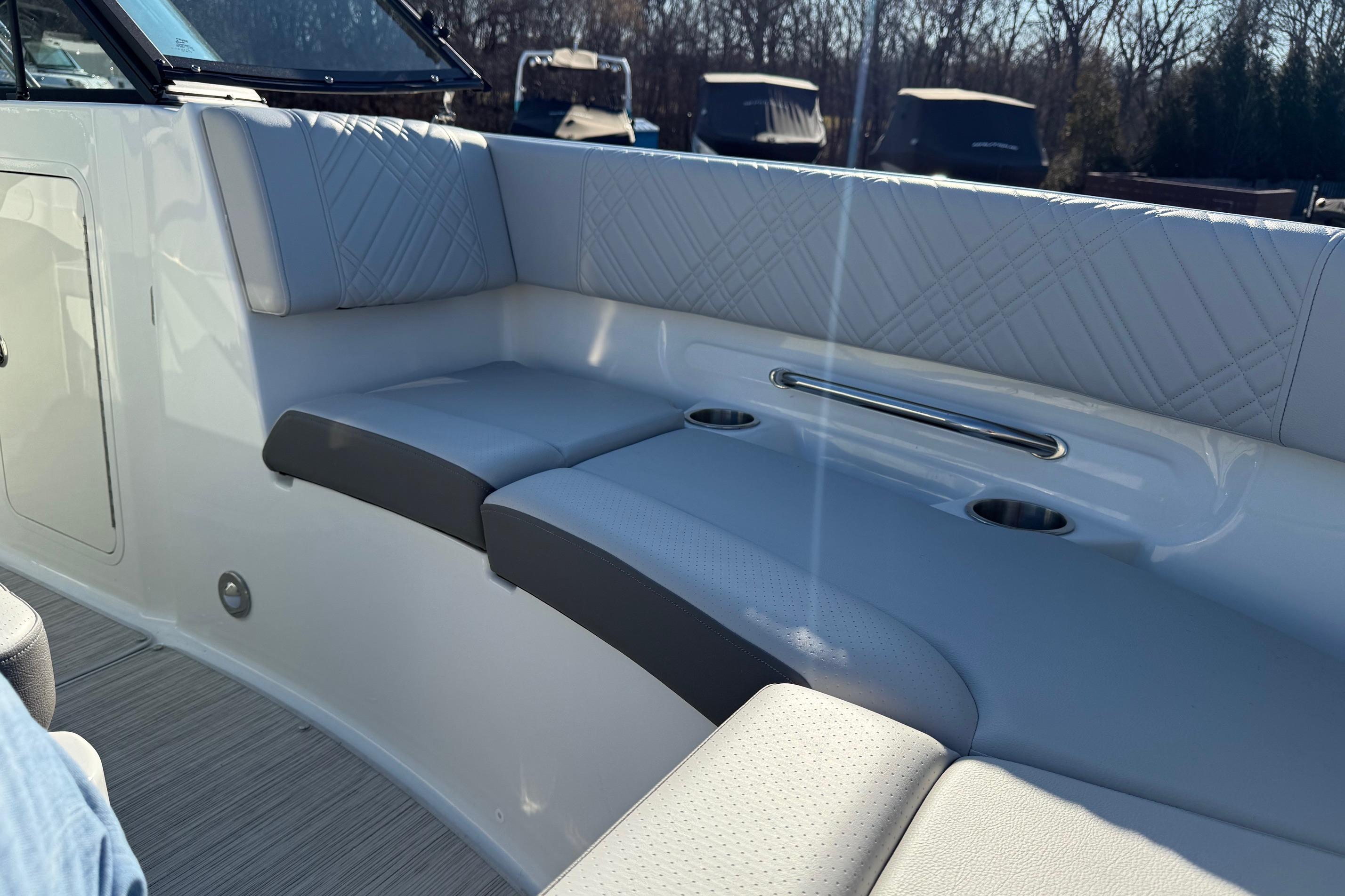 2026 Sea Ray SDX 230 boat interior with cushioned seating and cup holders.
