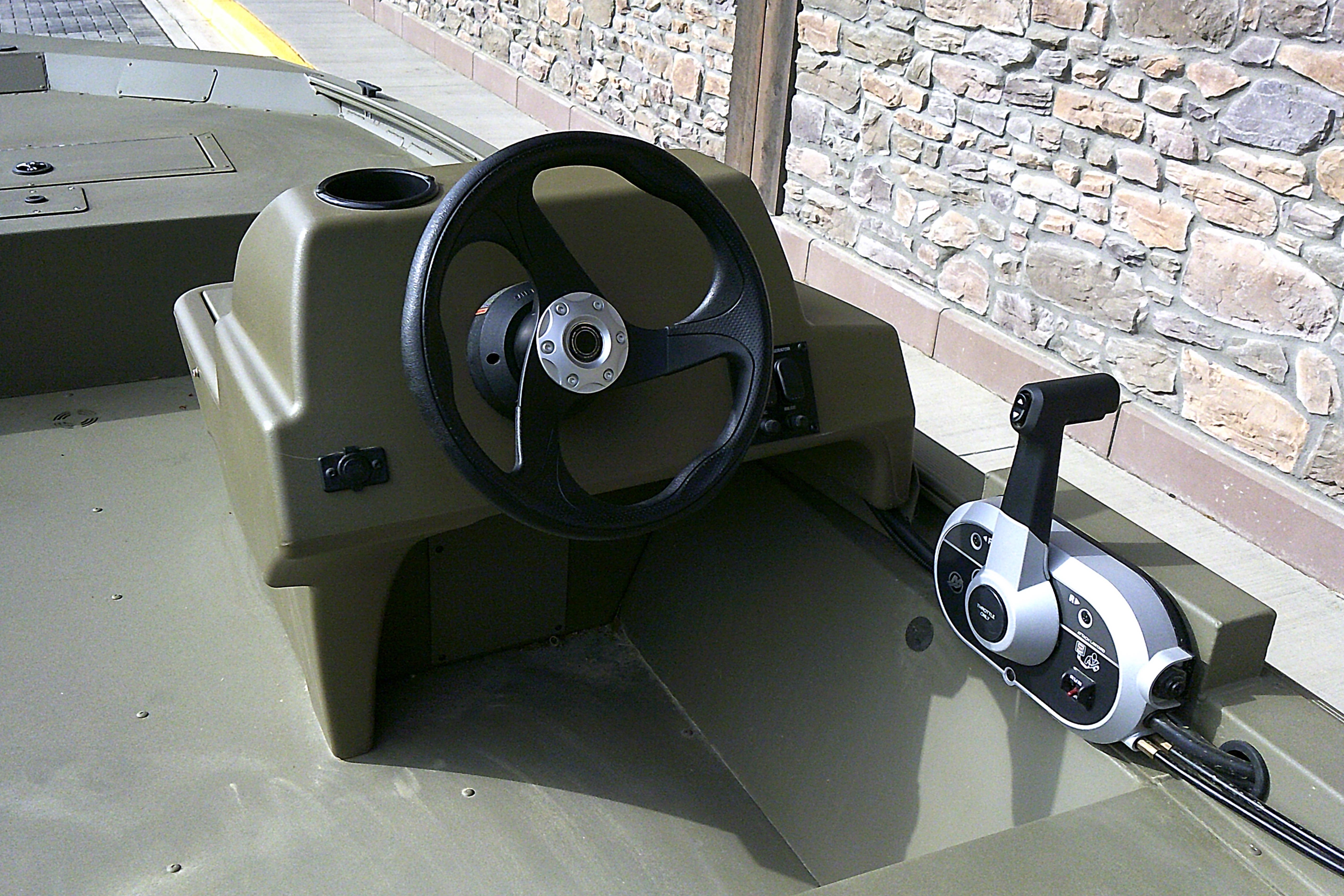 Steering console of 2026 Tracker Grizzly 1648 SC boat with control lever.
