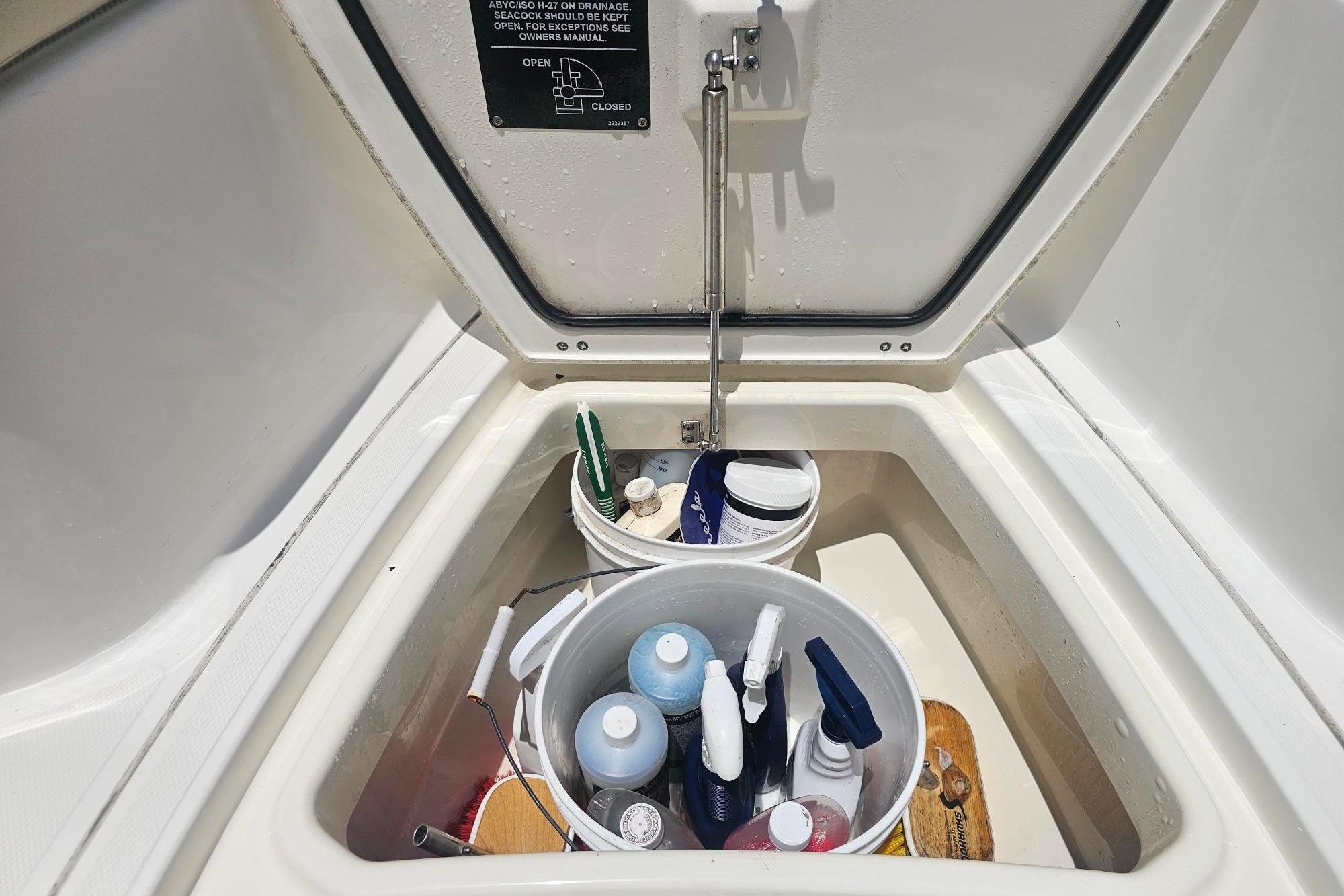 Storage compartment on a 2017 Boston Whaler 230 Outrage, containing cleaning supplies.