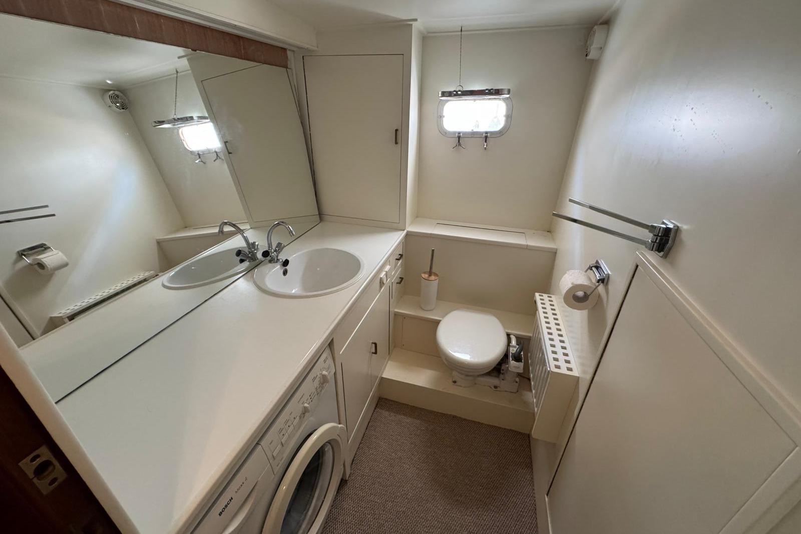 Bathroom interior of 1991 Super Van Craft 15.50 yacht with dual sinks and washing machine.
