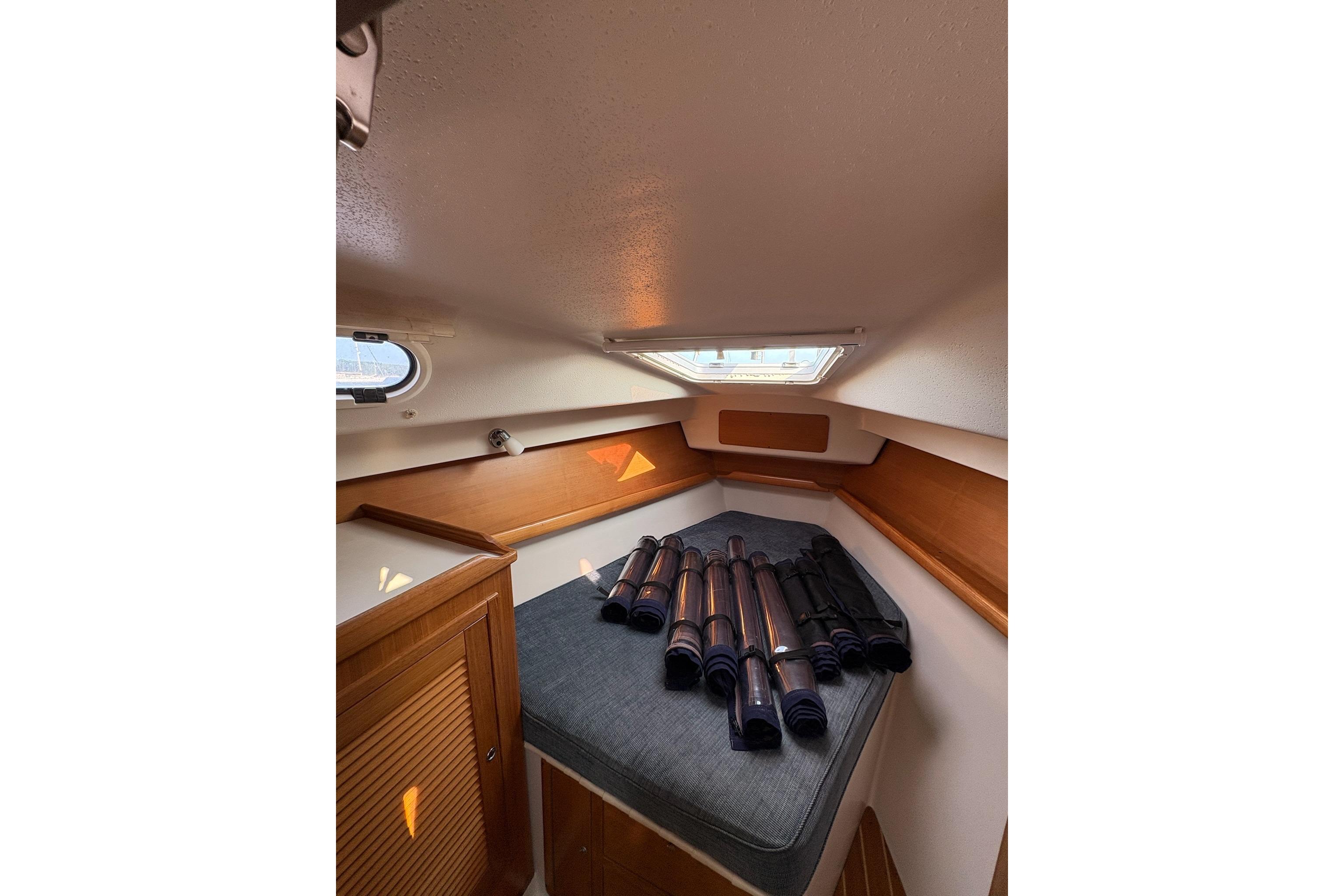 Cozy cabin interior of 2003 Catalina 387 sailboat with rolled sails on bed.