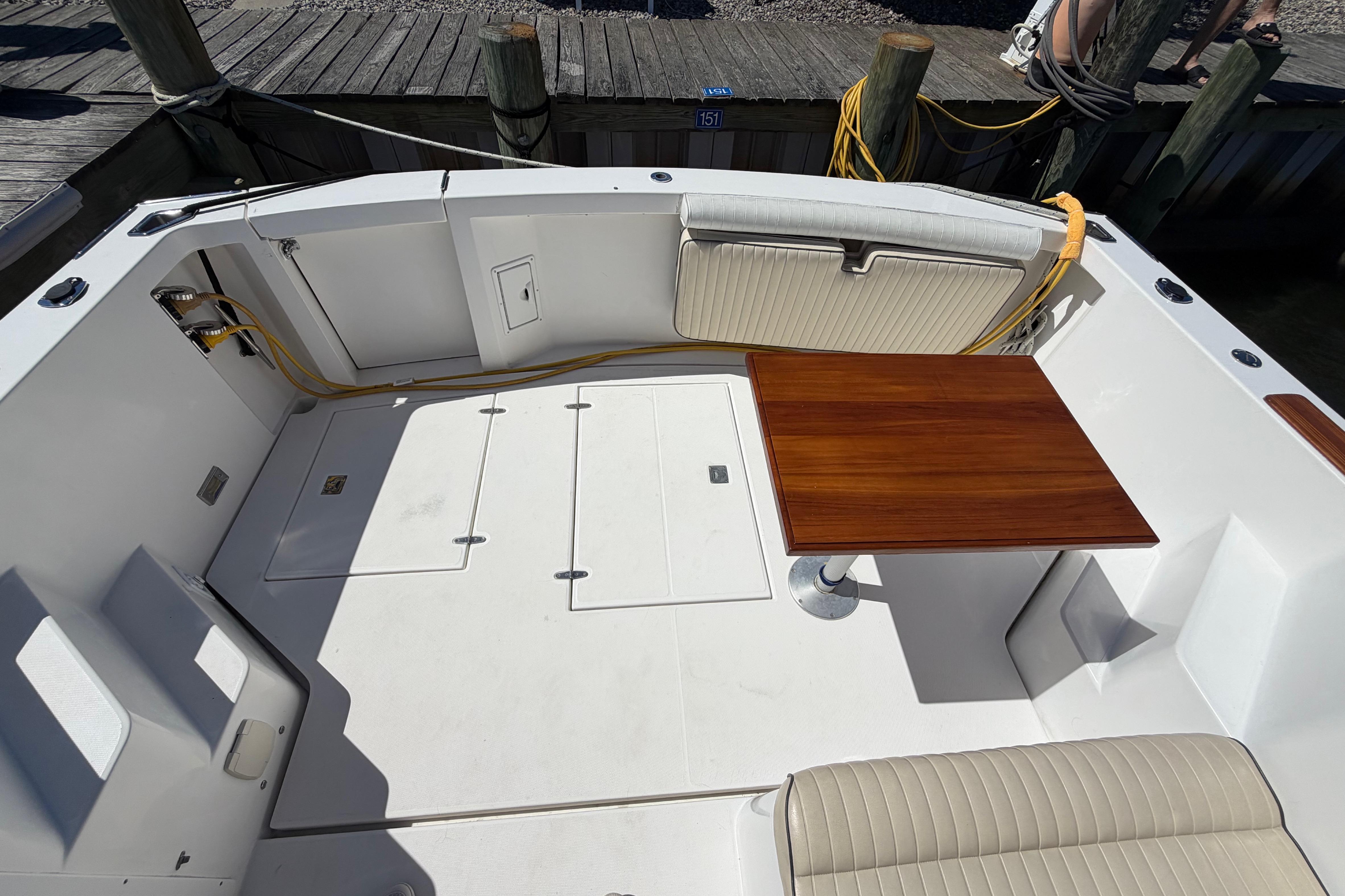 2000 Sabreline 36 Express boat deck with wooden table and cushioned seating.