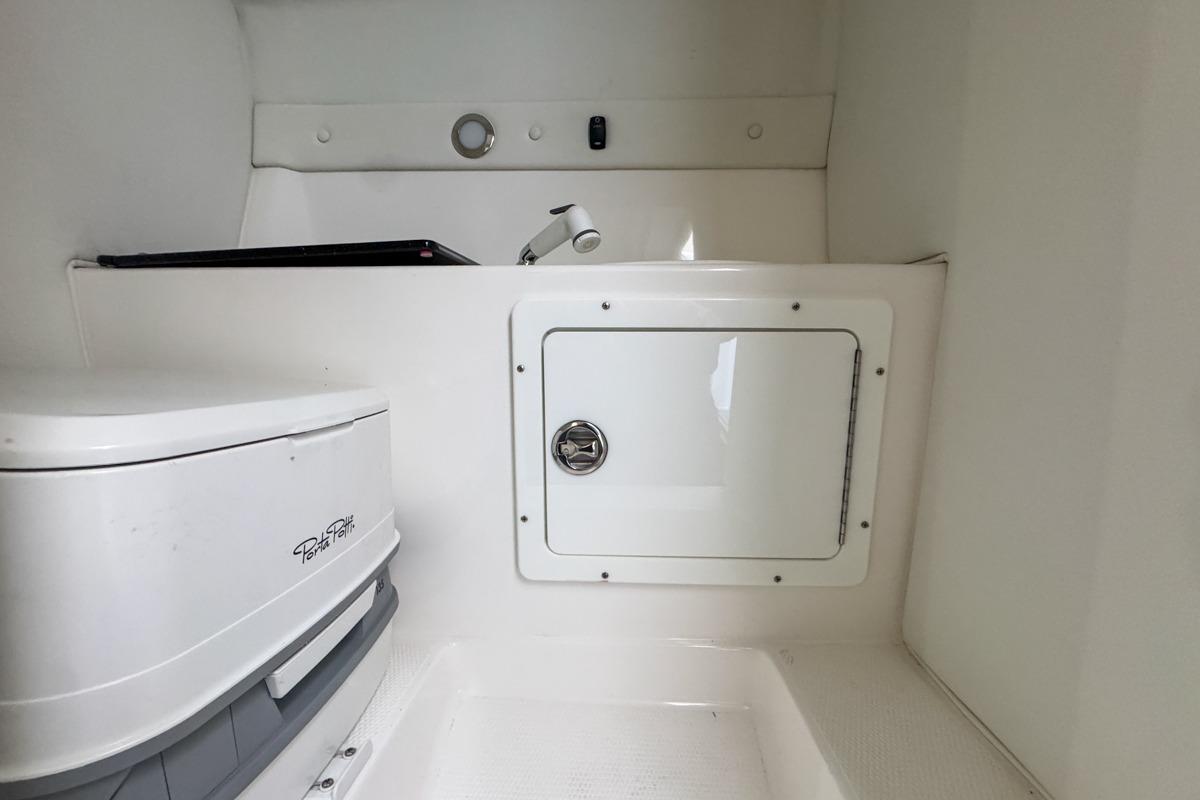 2022 Velocity 290sc boat interior with compact toilet and storage compartment.