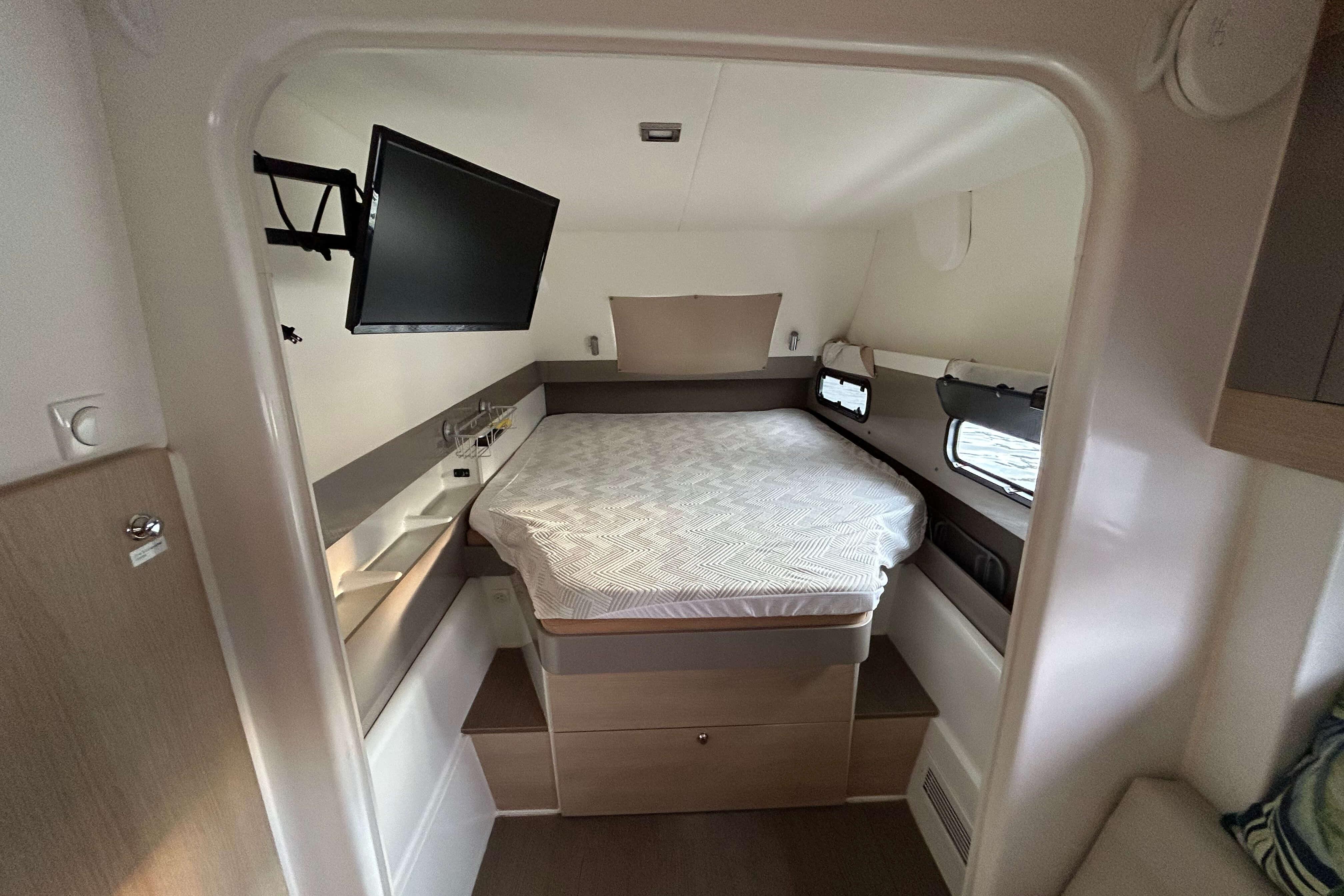 Compact bedroom in 2018 Bali 4.1 yacht with bed, TV, and windows.